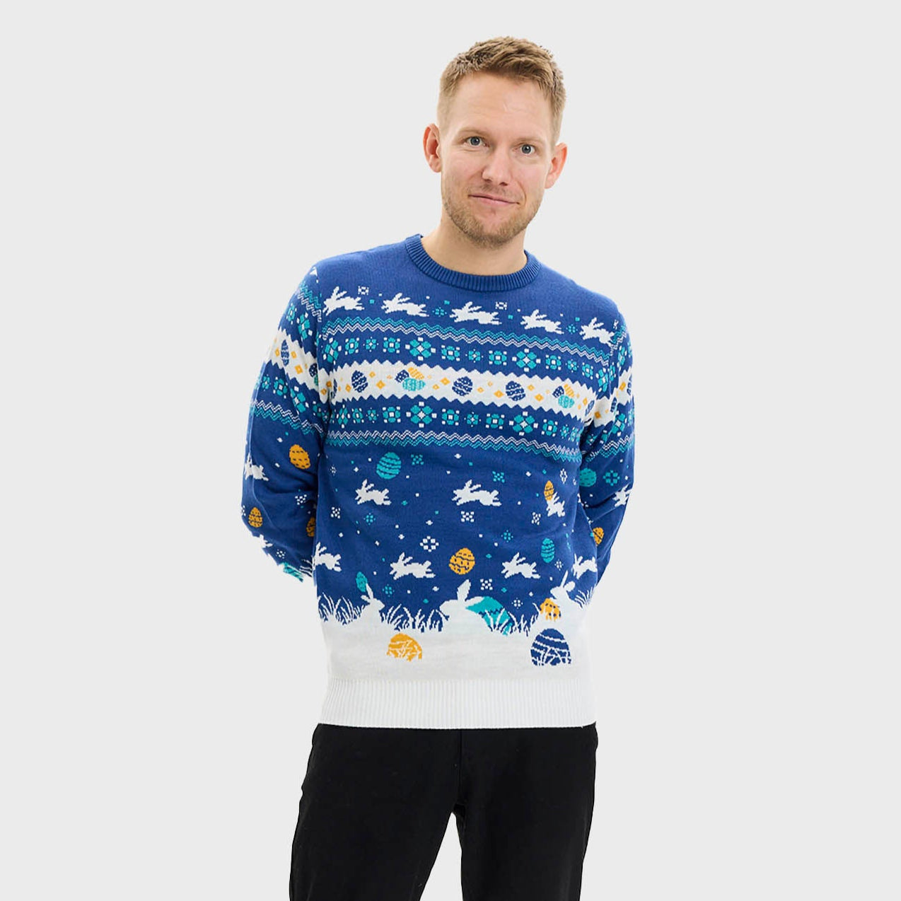 En man klädd i en blå påsktröja med påskkärringar på.