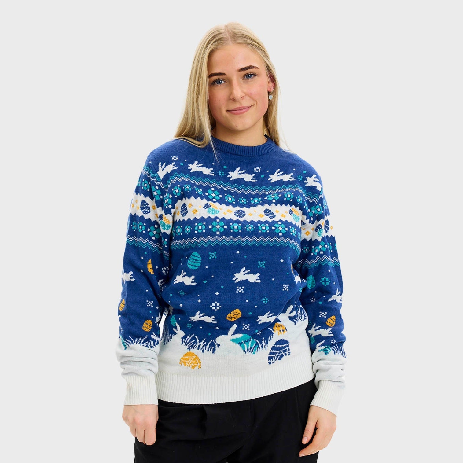 En kvinna som bär en blå påsktröja med påskkärringar på.