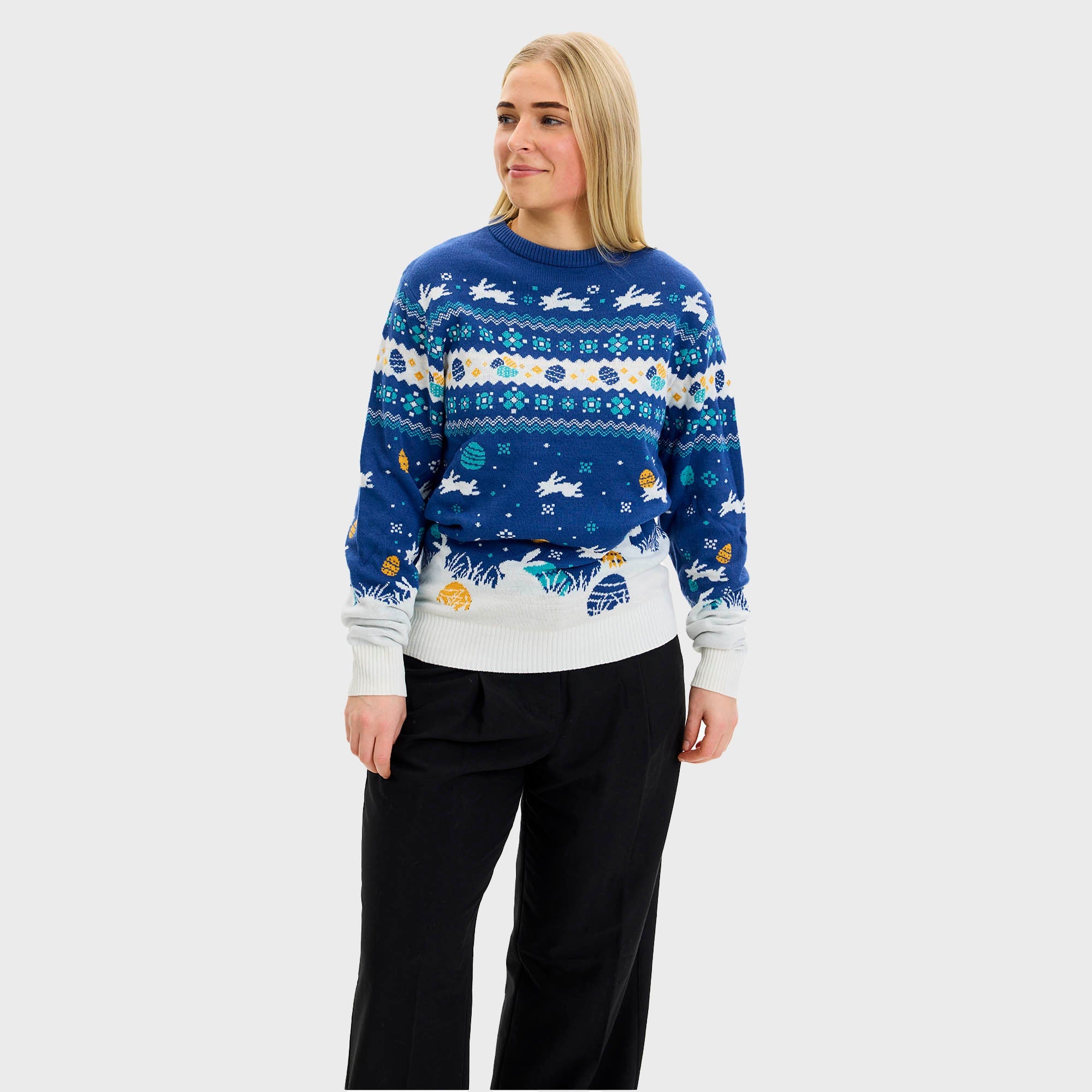 Ett par tittar på en påskkärring och bär en blå påsktröja med påskkärringar på.