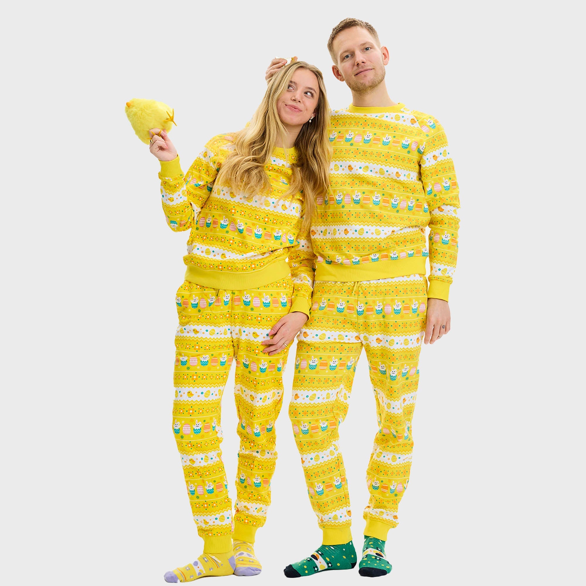 Ett par i en randig gulvit påsktröja.