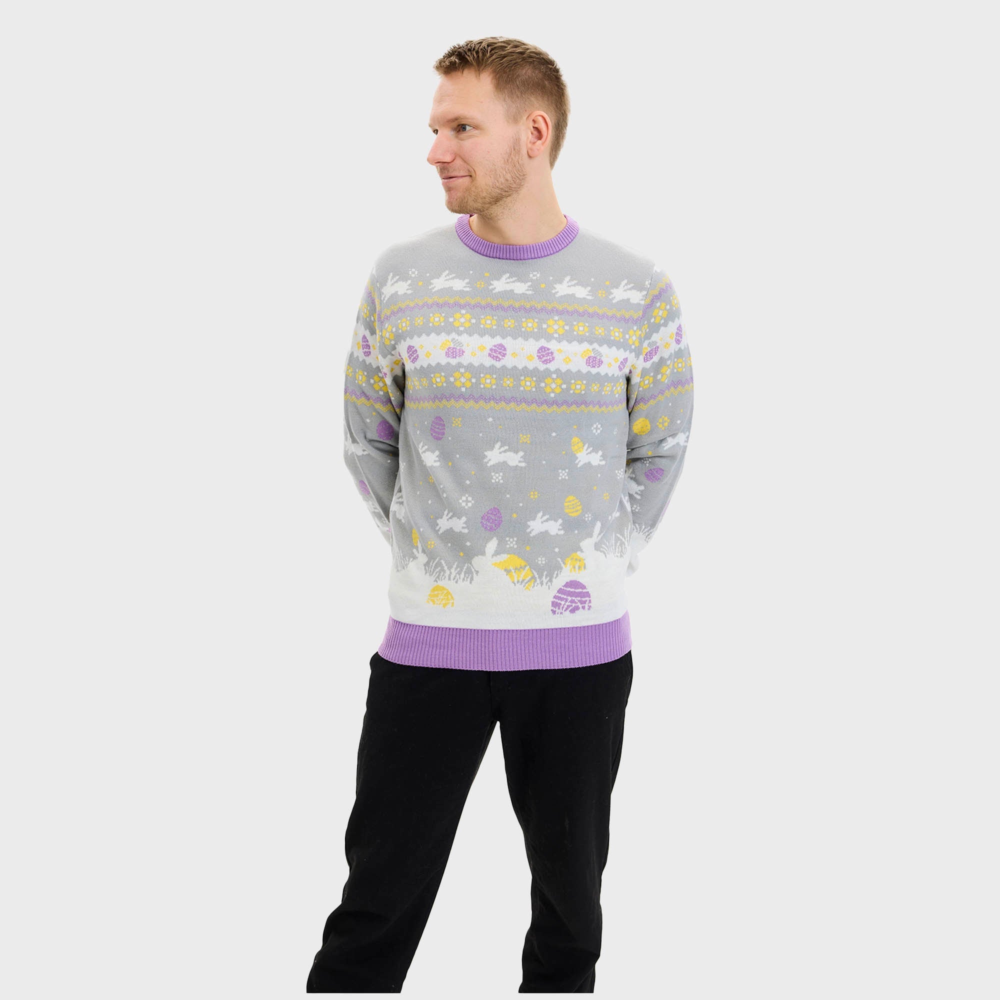 En man i en grå påsktröja med påskkärringar på.