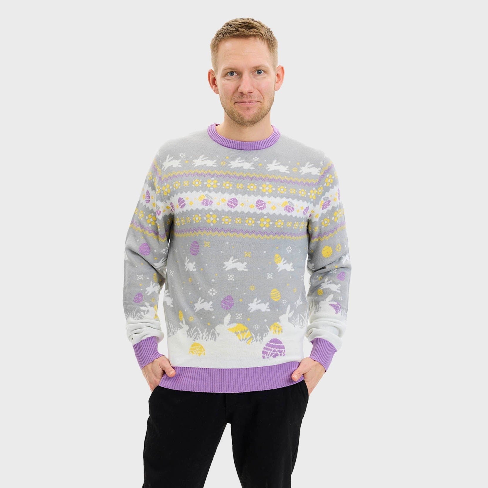 En leende man i en grå påsktröja med påskkärringar på.