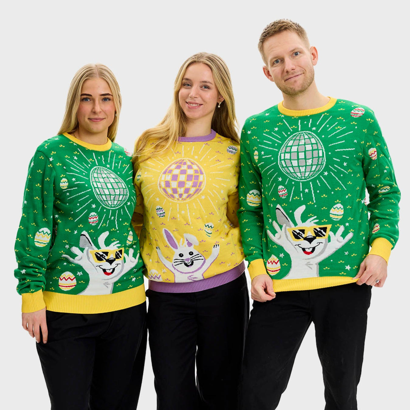 En kvinna i grön påsktröja med discokula och en kanin.