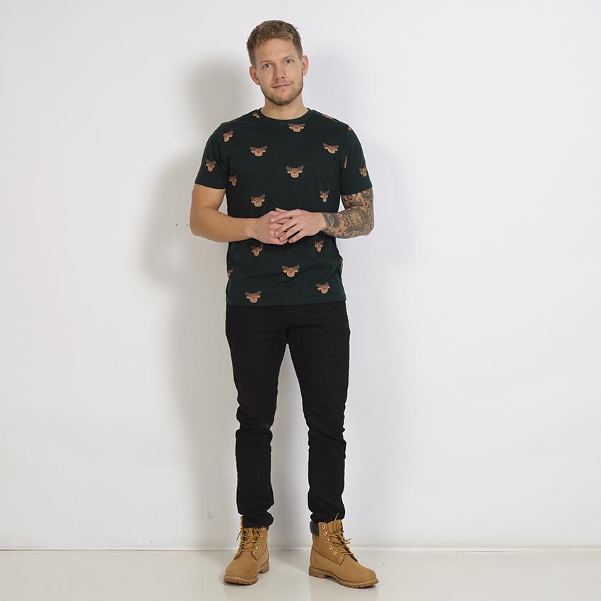 En man klädd i en mörkgrön T-shirt med renar på.