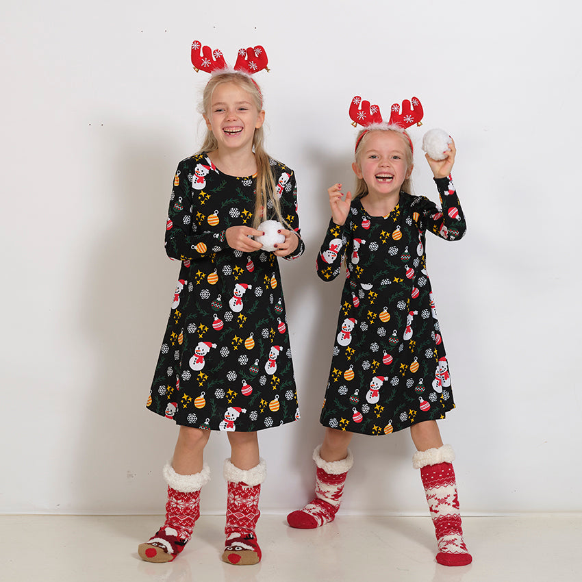 Två barn i svarta julklänningar.