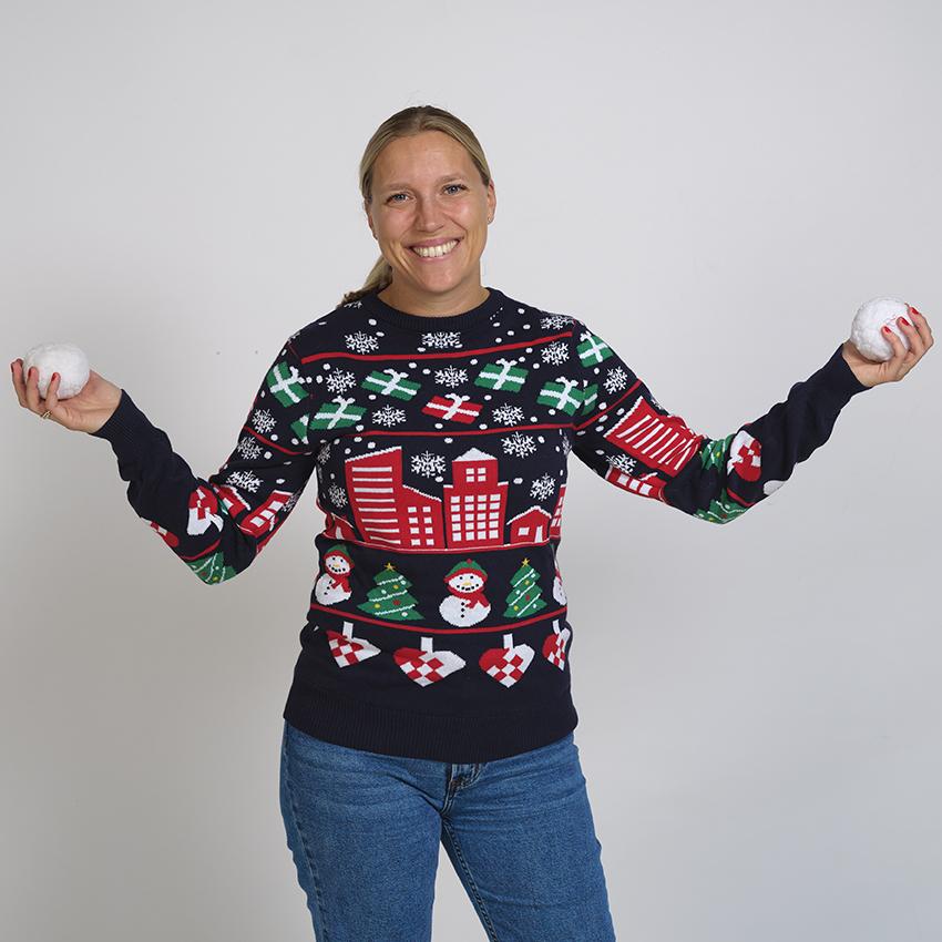 En poserande kvinna i jultröja med en stadskalender på.