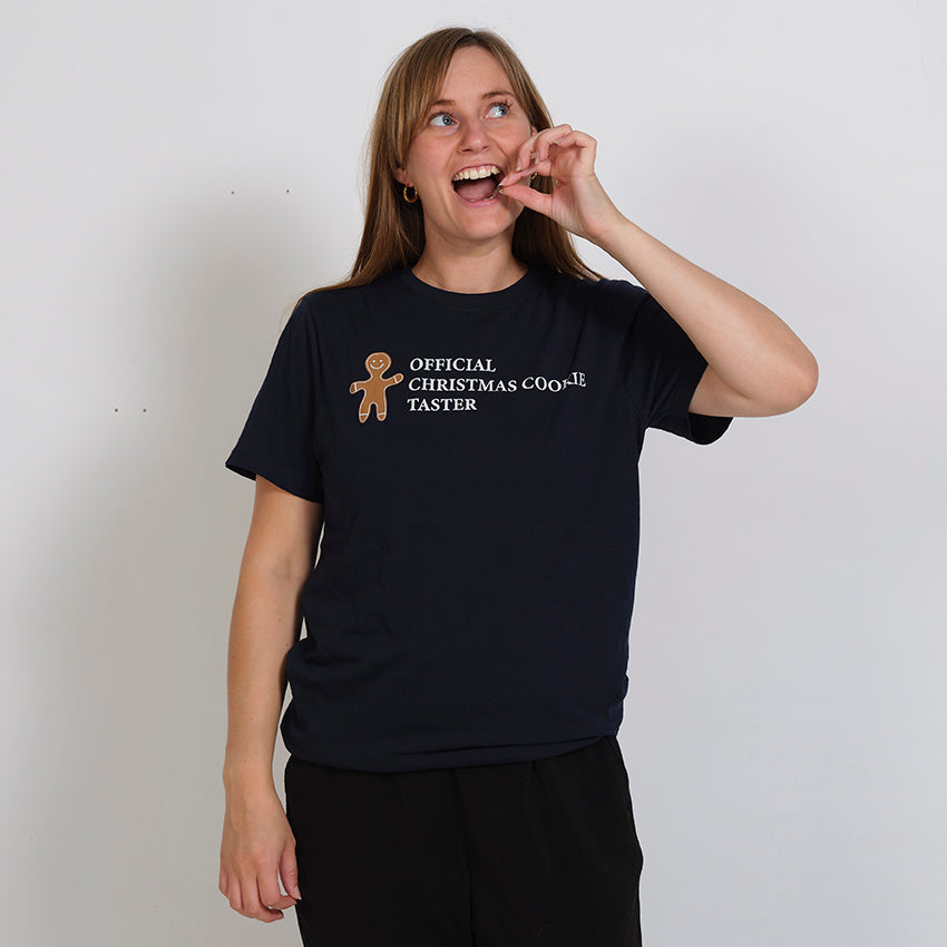 En dam klädd i en svart T-shirt med en tårtman på.