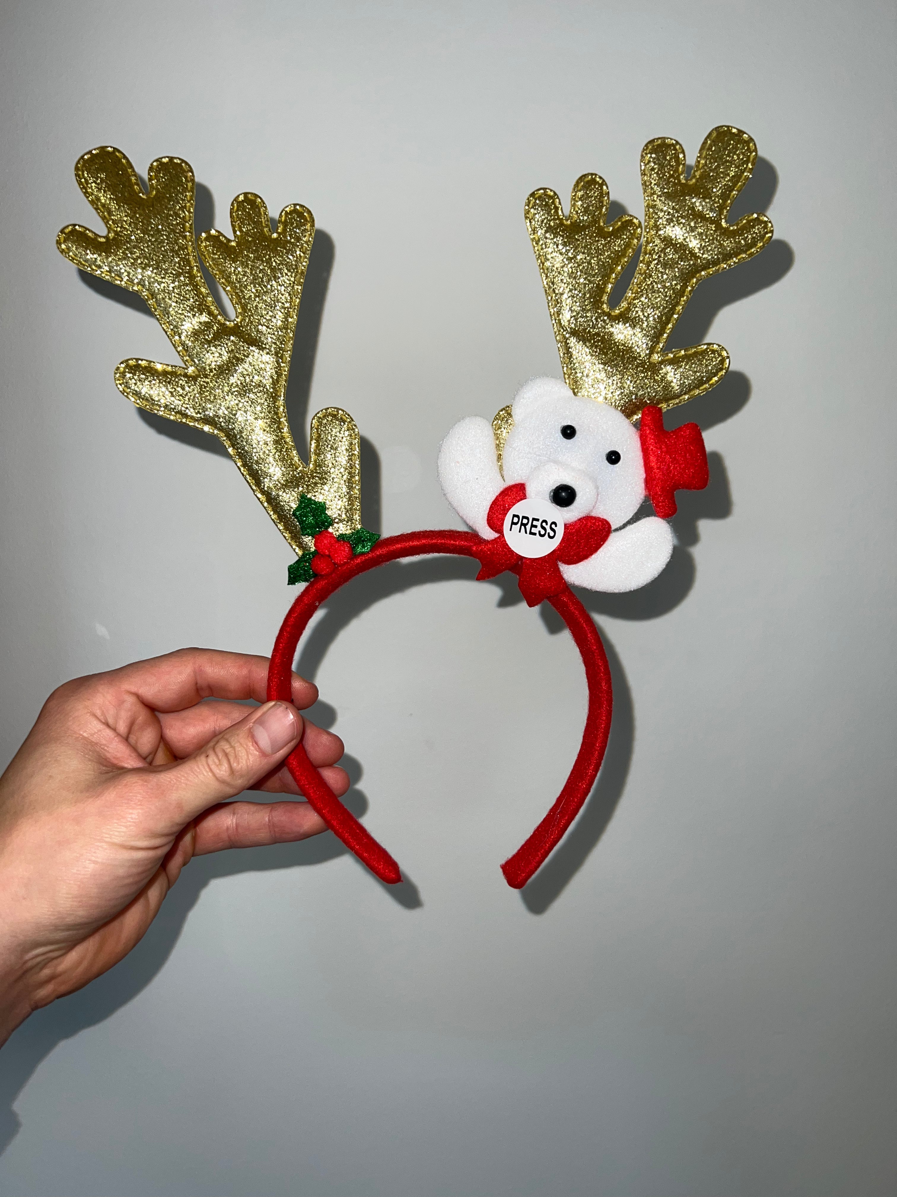 En röd och guldfärgad hårscarf som liknar ett renhorn.