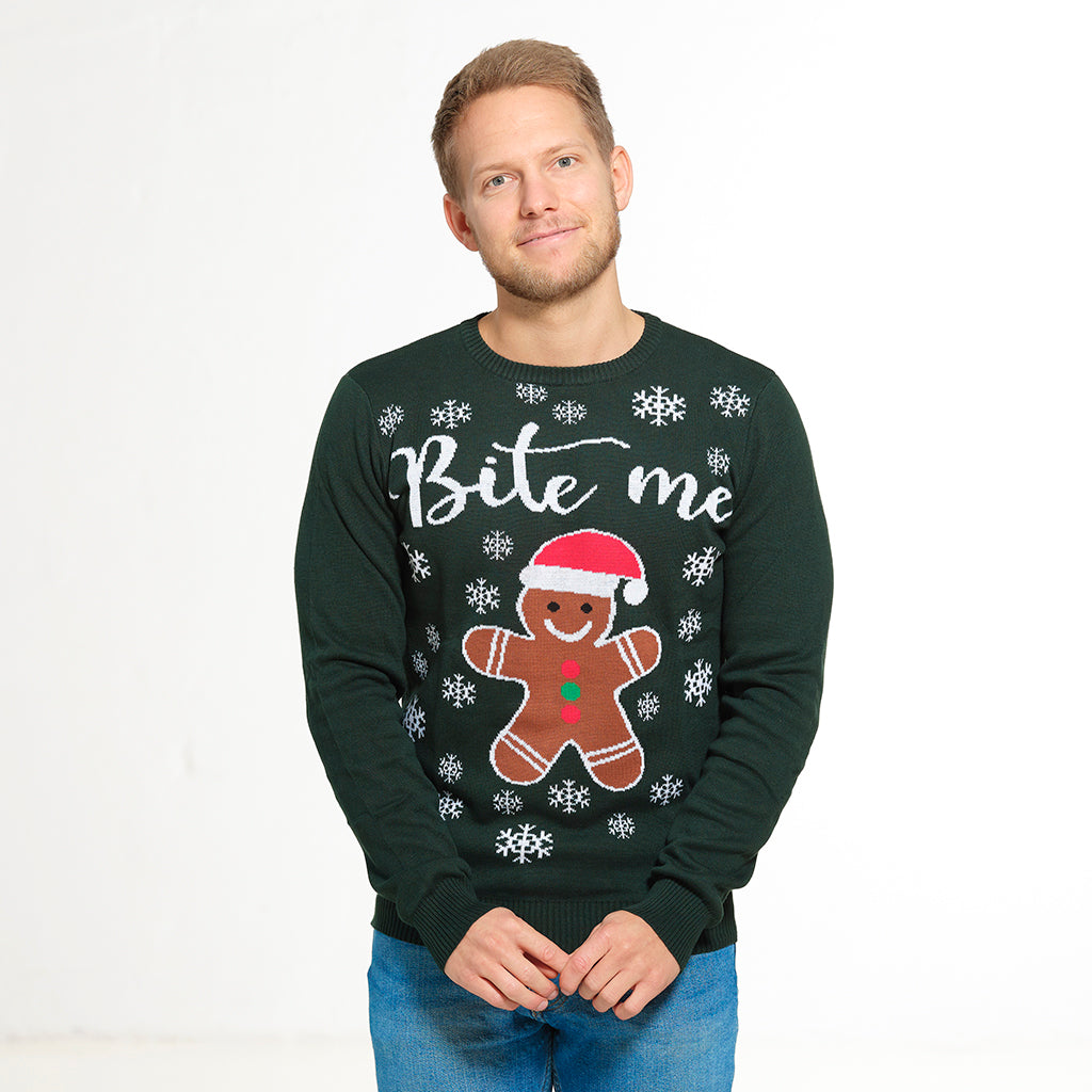 En man i en grön jultröja med en kaka och citatet 