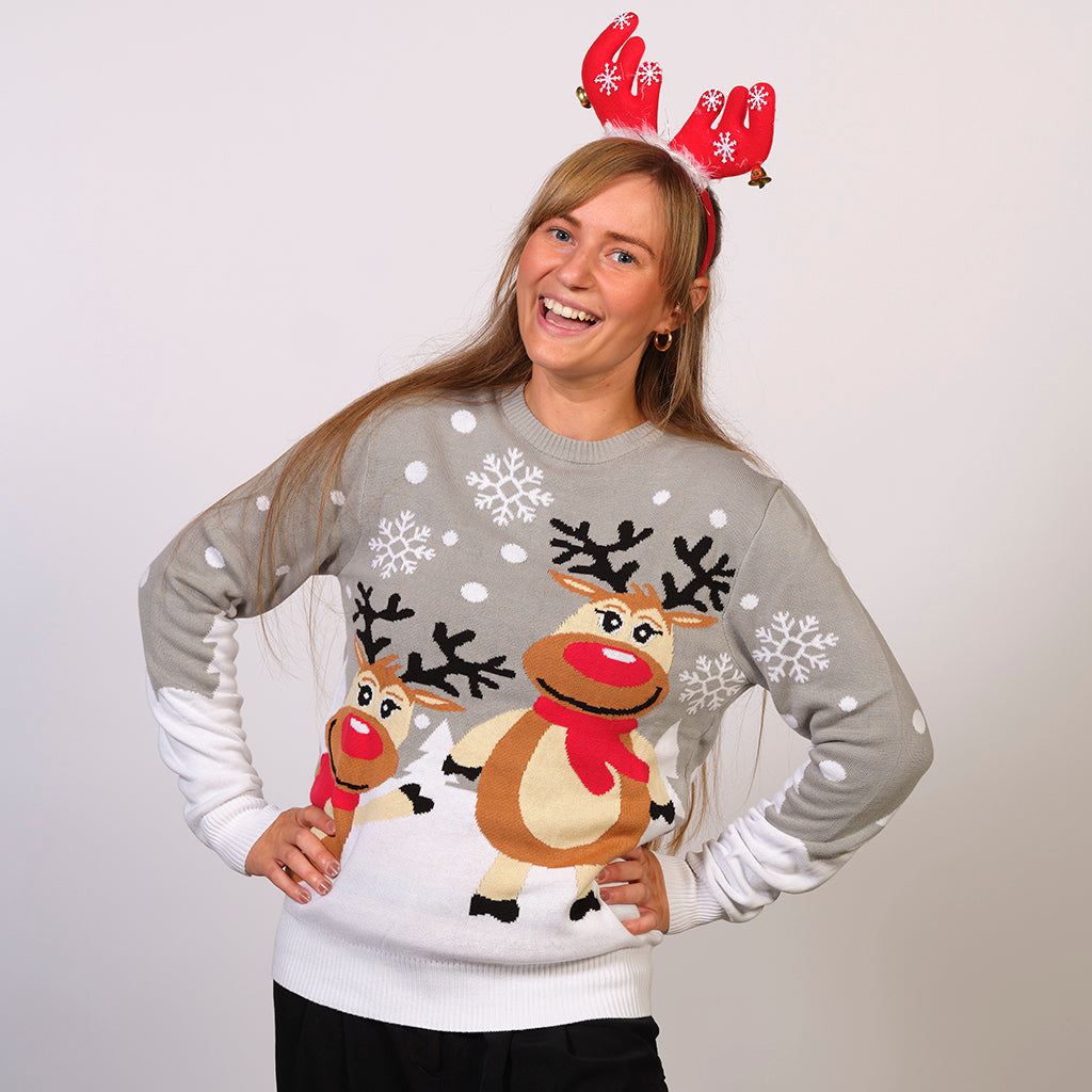 Kvinna i grå jultröja med renar och snöflingor.