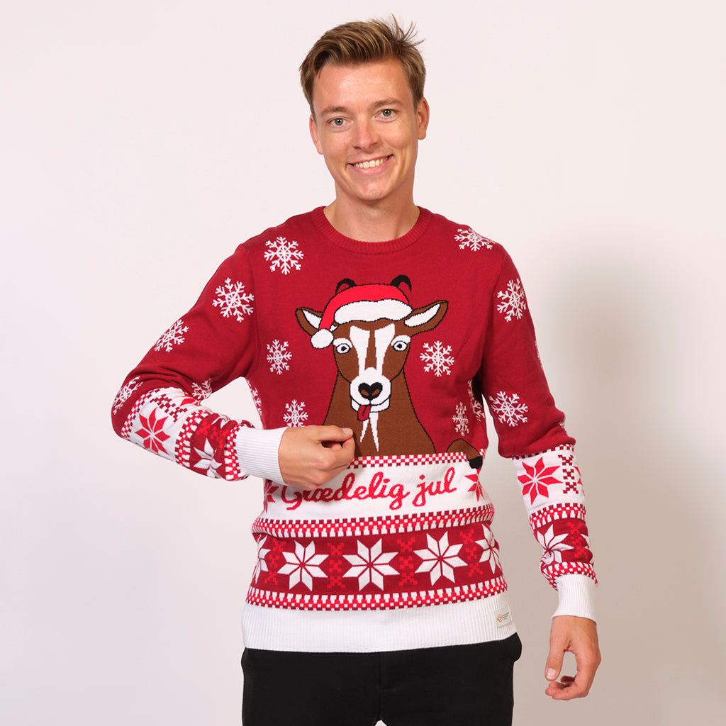 En man i en röd jultröja med hjort och snöflingor.