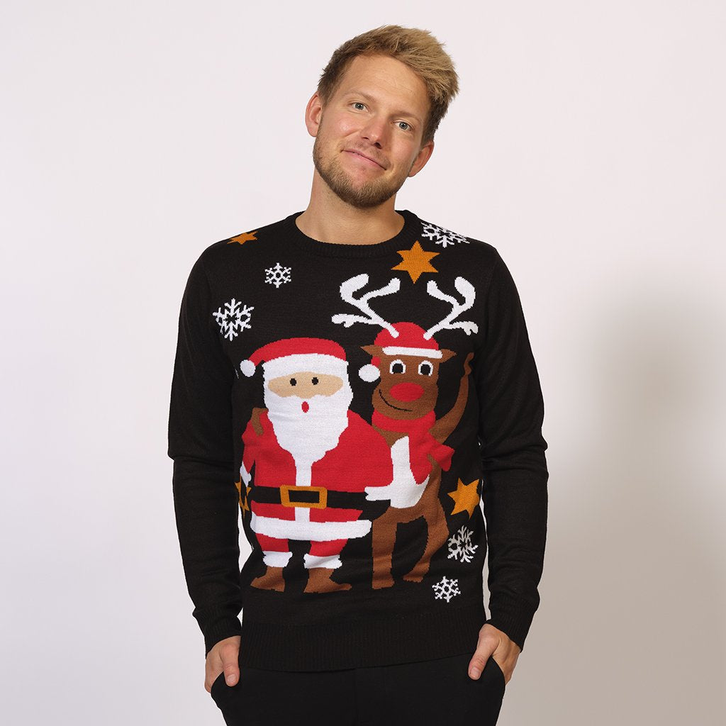 En man i svart jultröja med jultomten och Rudolf på.