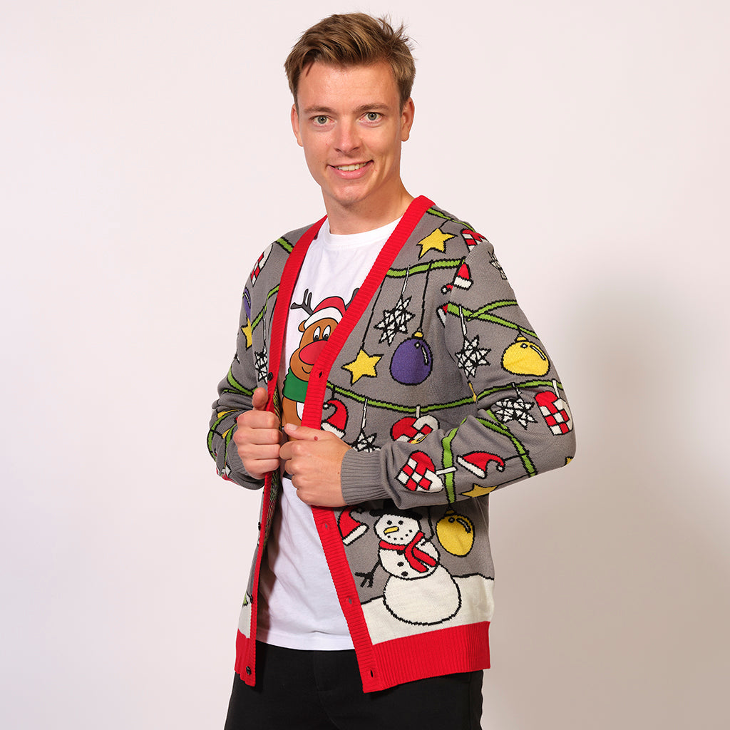 Man i grå julkofta med snögubbar, julgranar och juldekorationer.