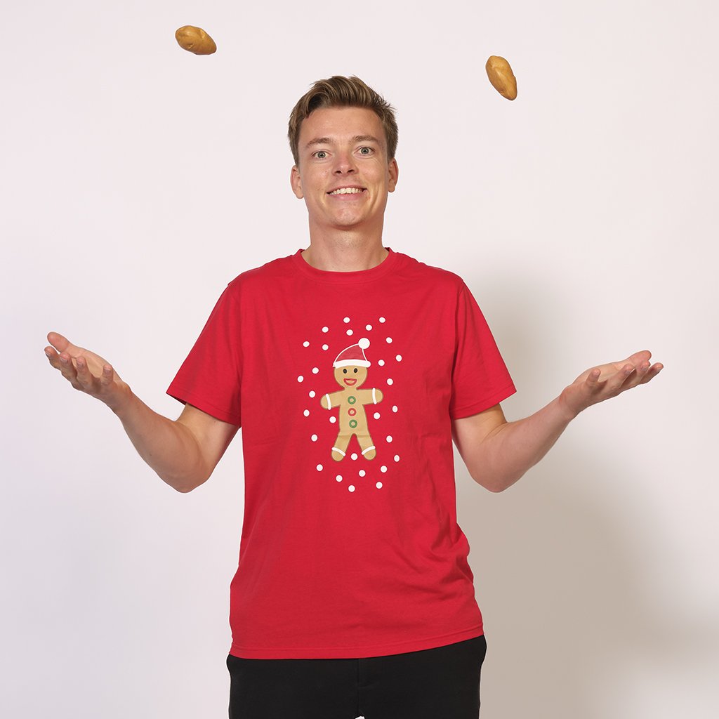 En man klädd i en röd jultröja med en kaka på.