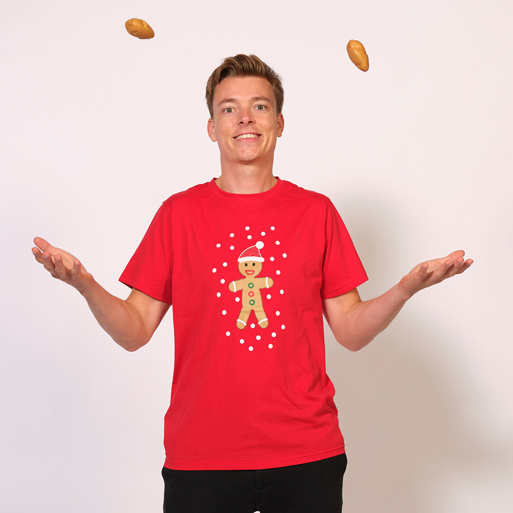 En man klädd i en röd jultröja med en kaka på.