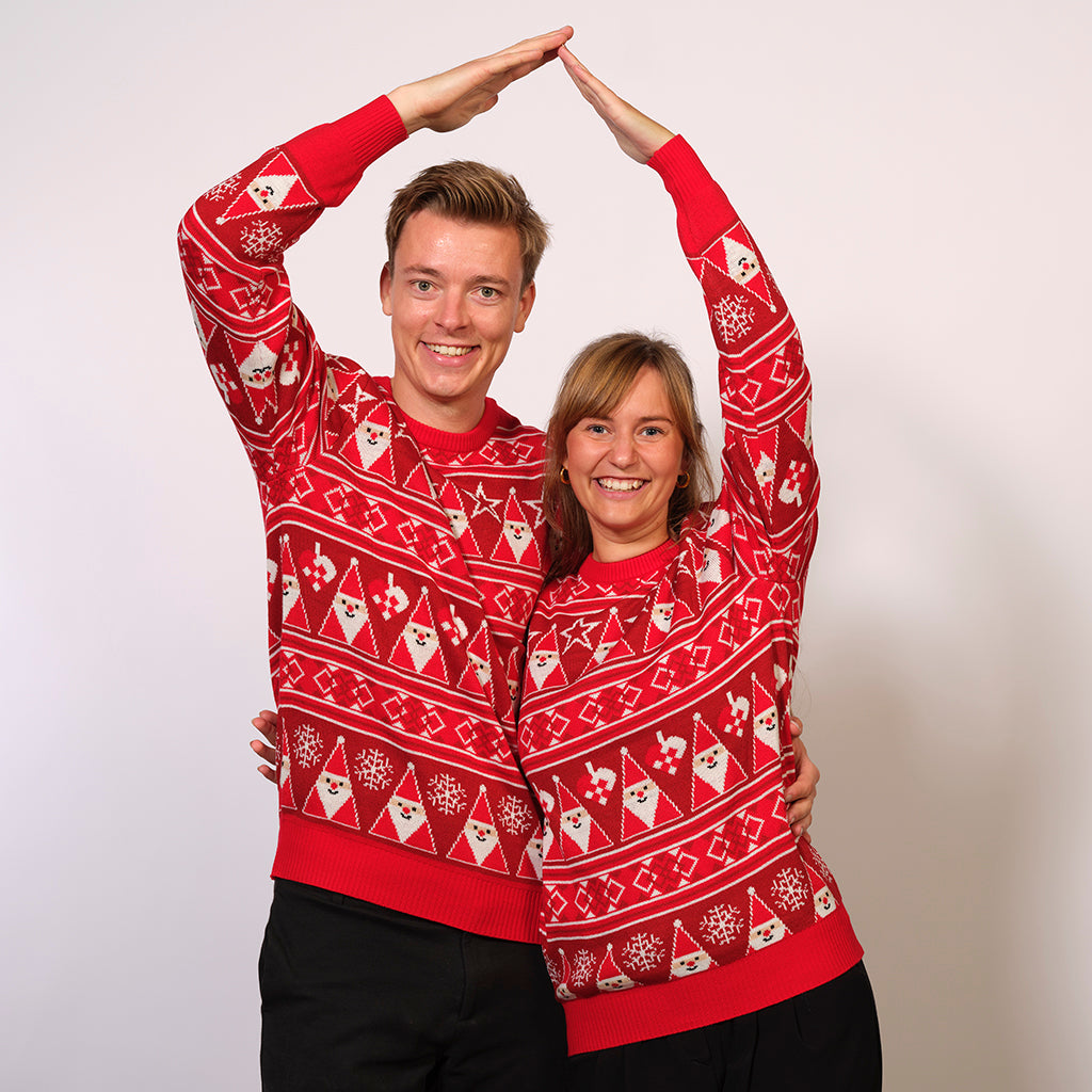 Ett par i en röd jultröja med tomtar och mönster.