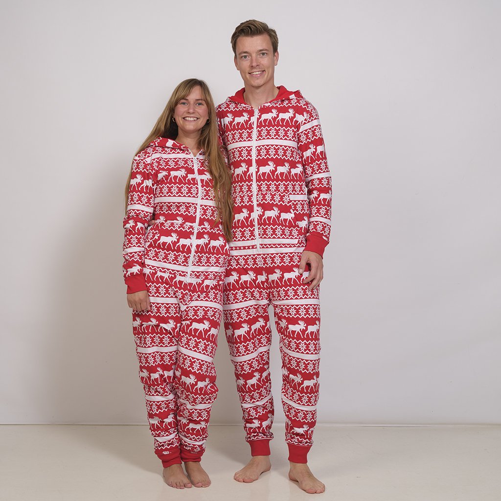Ett par i en röd jumpsuit med julmönster.