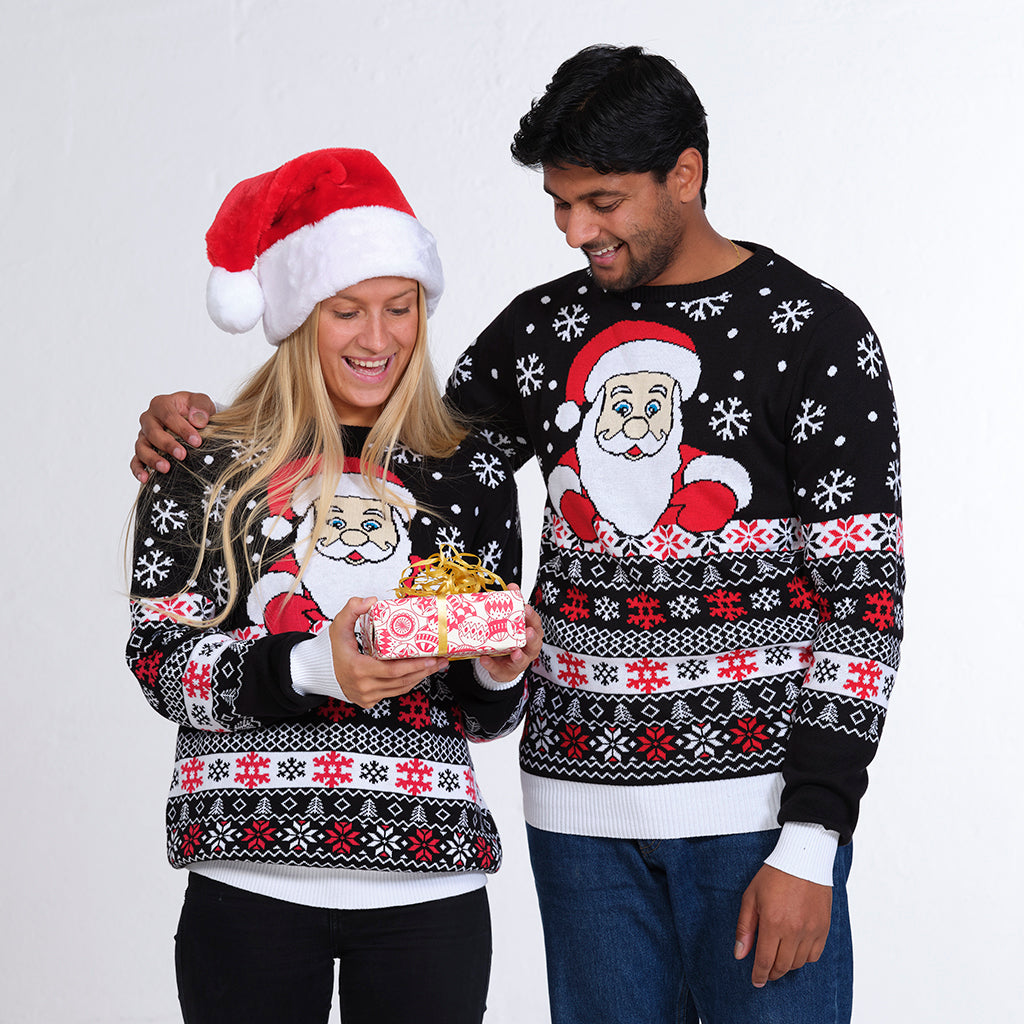 Ett par i mörkblå jultröja med jultomten och snöflingor.