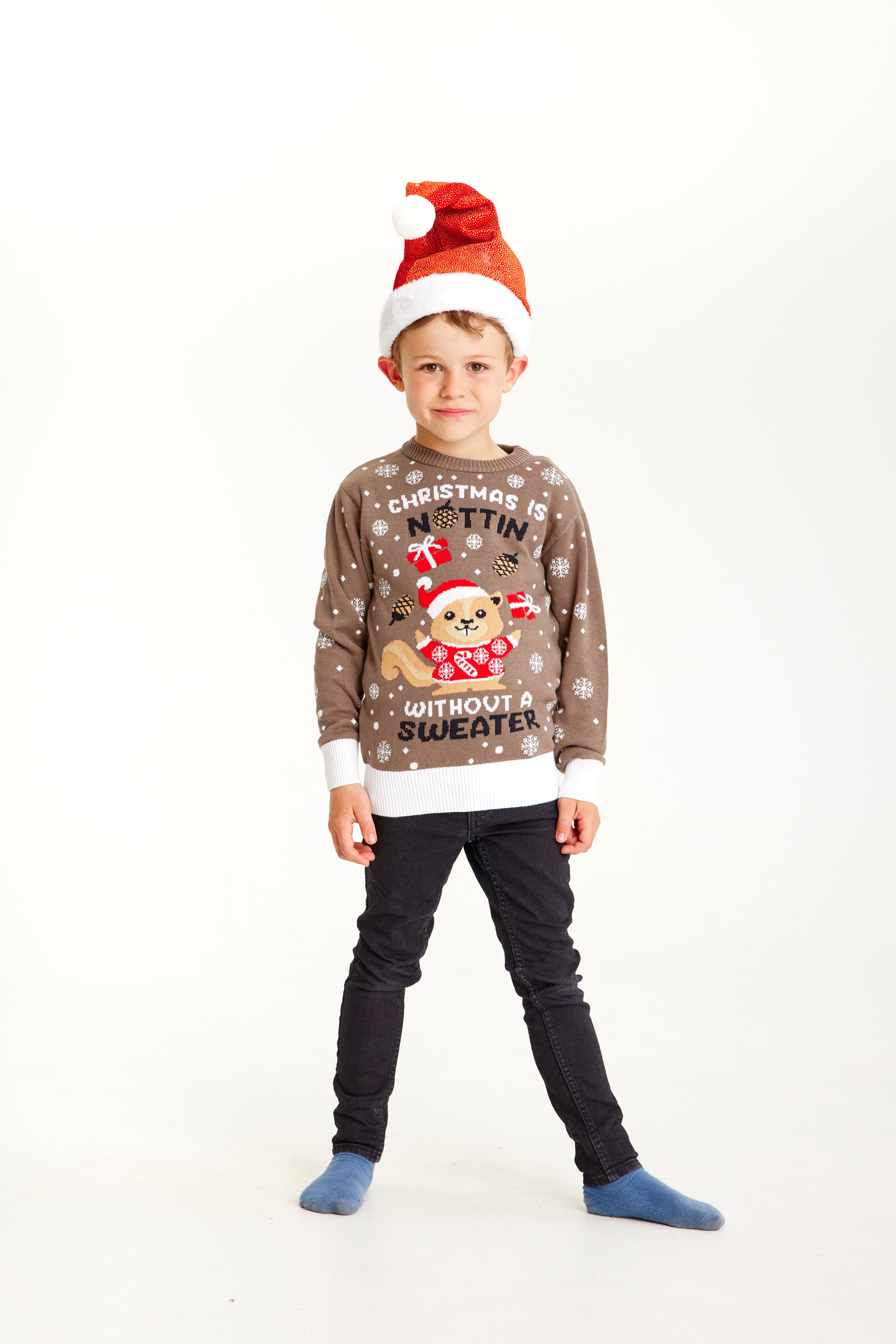 Ett barn med en brun jultröja med snöflingor.