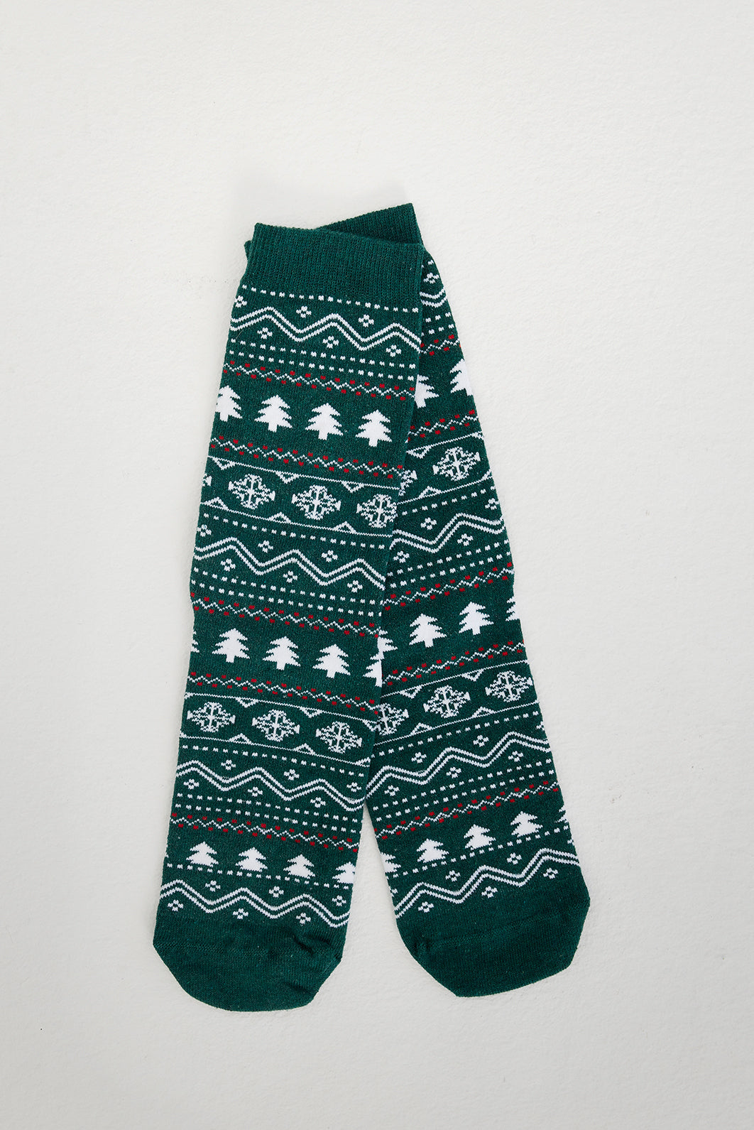 Ett par gröna julstrumpor med julgranar på.