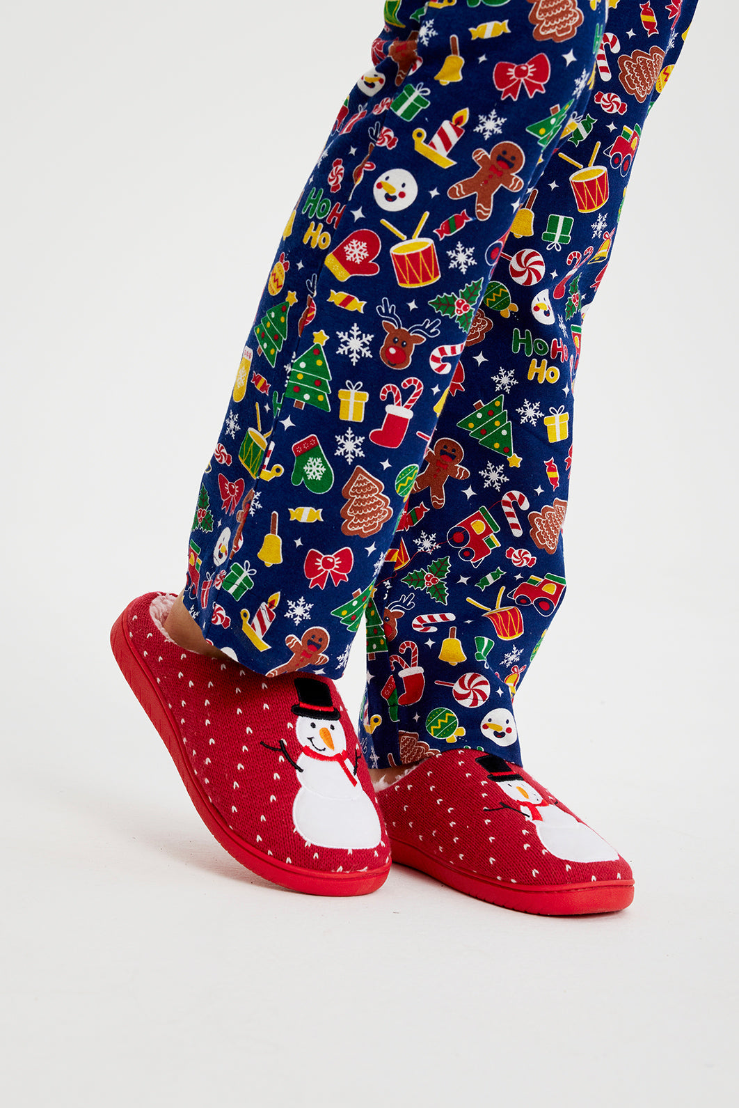 Ben i röda jultofflor med en snögubbe på.