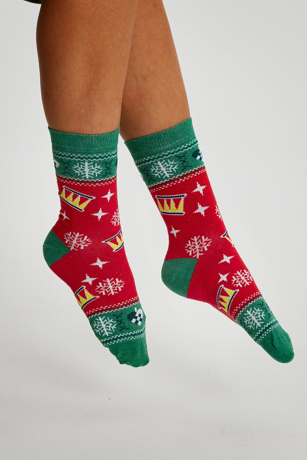 Ett par fötter med röda och gröna julstrumpor.