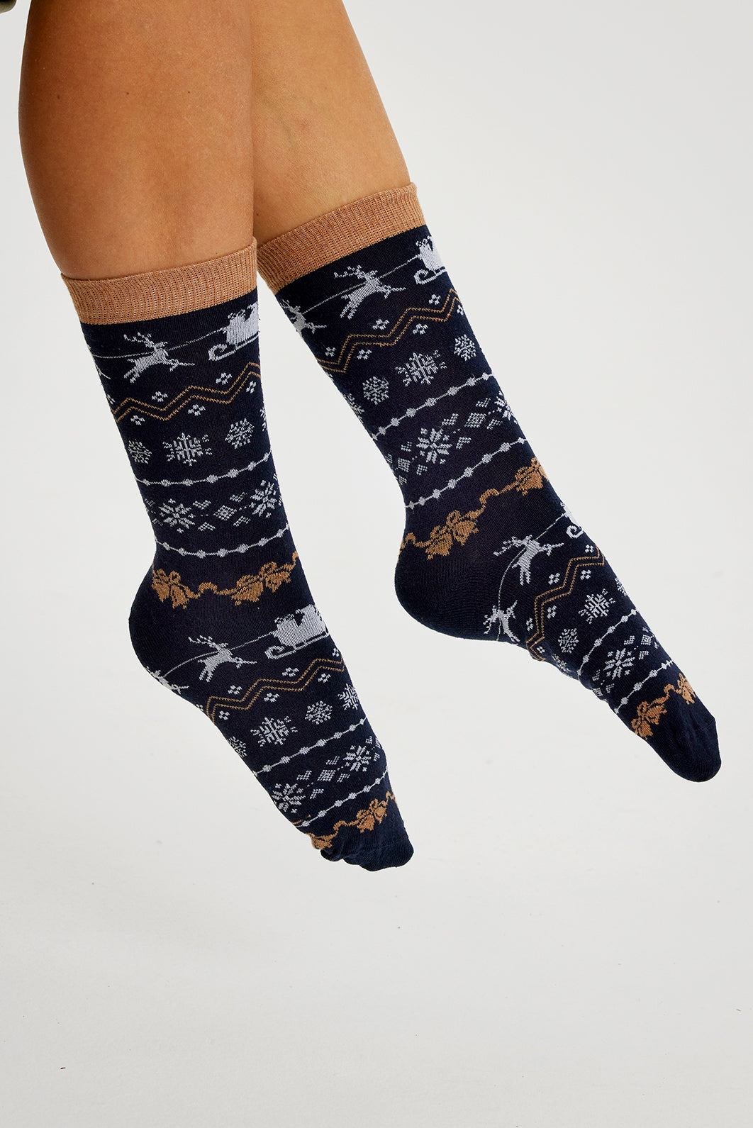 Ett par ben i blå julstrumpor med julmönster.