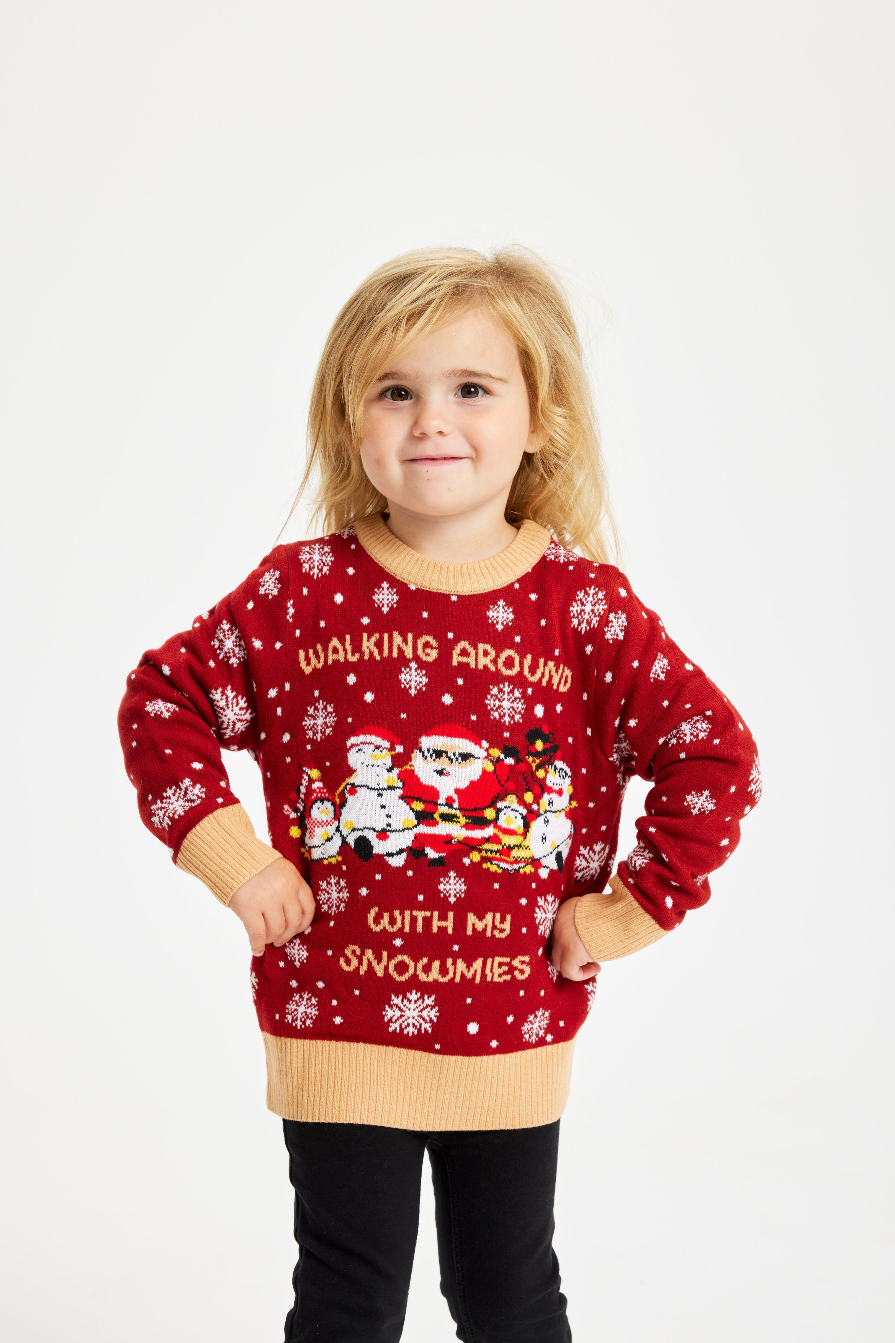 Ett poserande barn som bär en röd jultröja med ljus och texten 