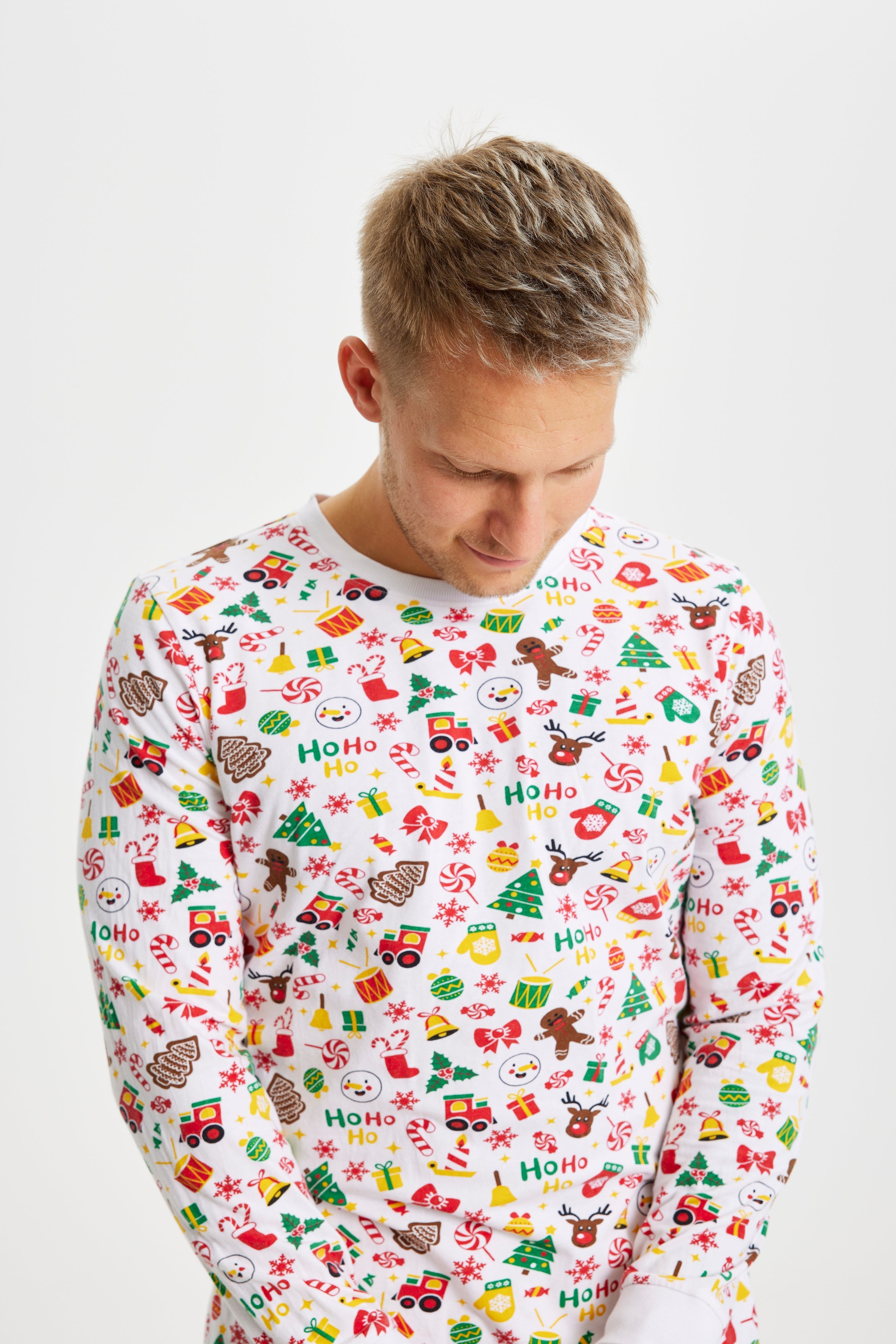 En poserande man i vit julpyjamas.