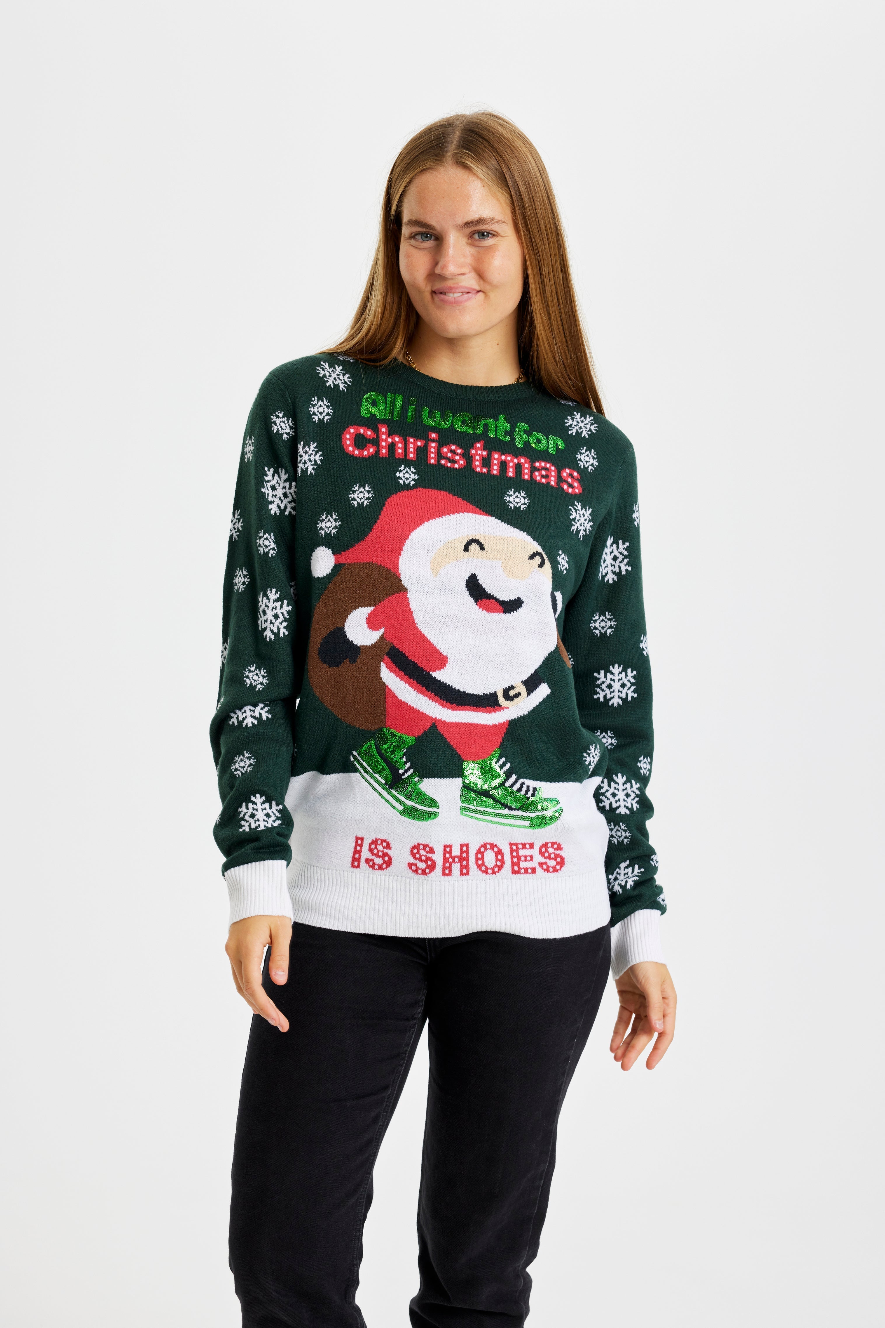 En leende kvinna klädd i en grön jultröja med texten 