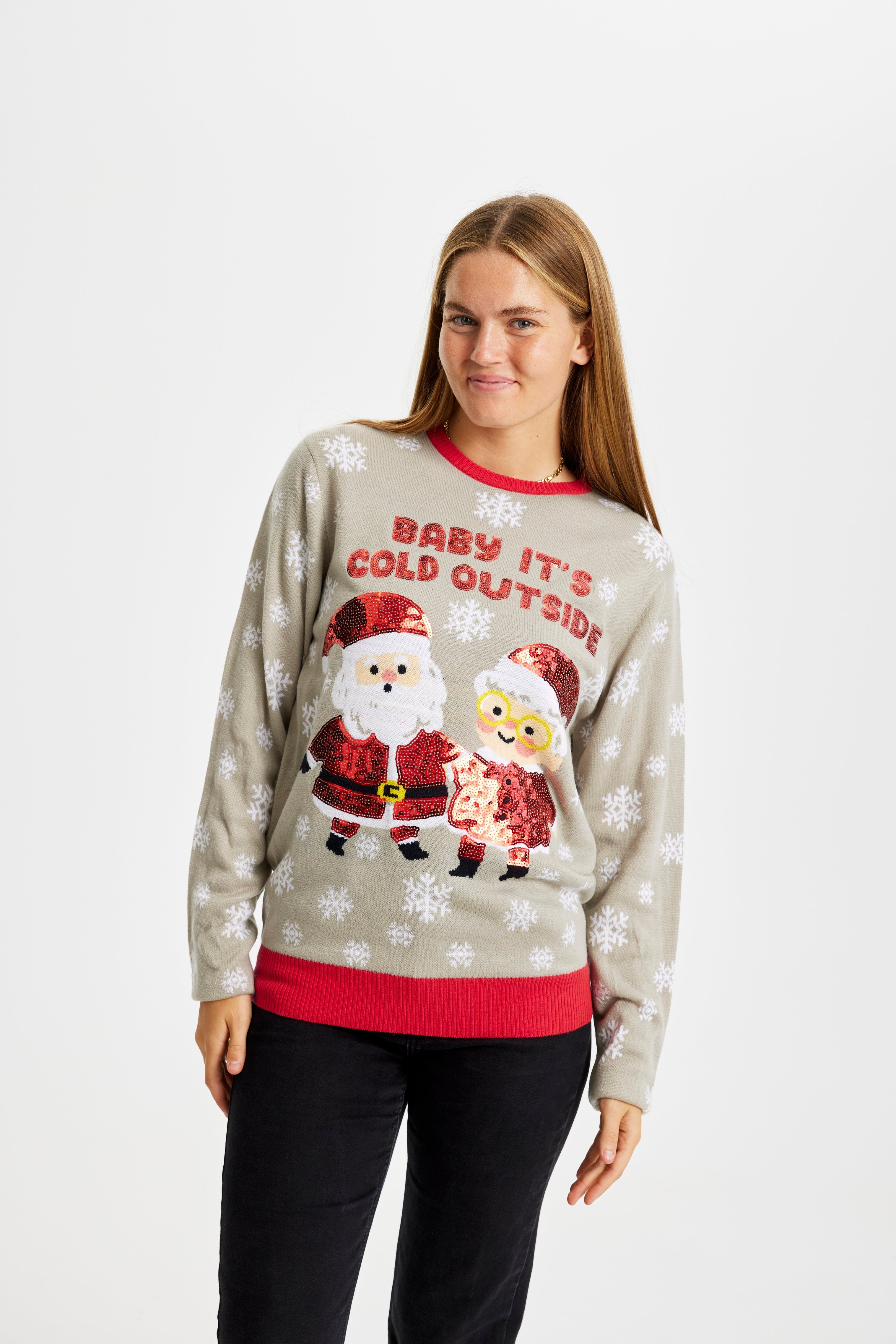 En leende dam klädd i en grå jultröja med citatet 