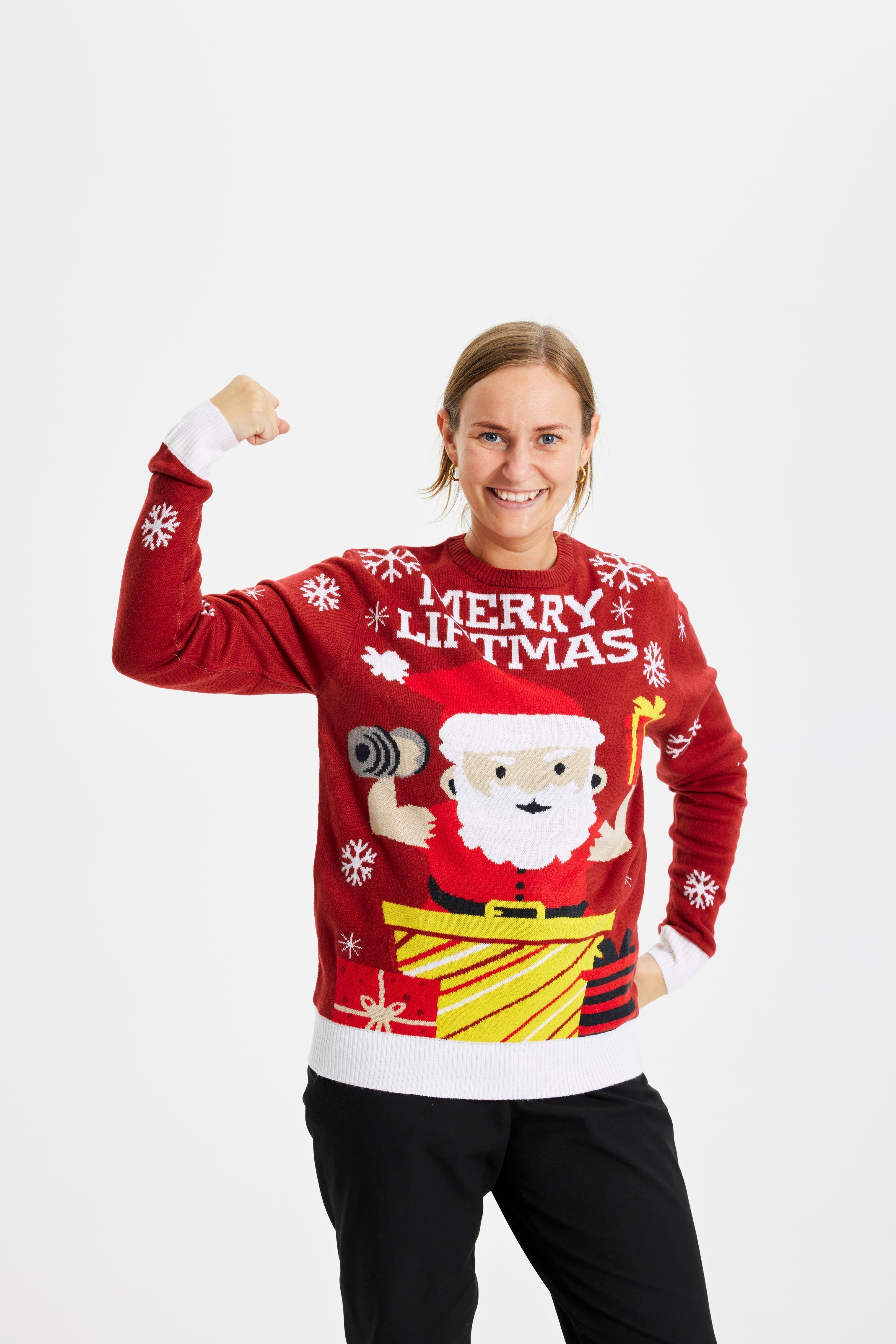 En leende kvinna poserar iklädd en röd jultröja med texten 