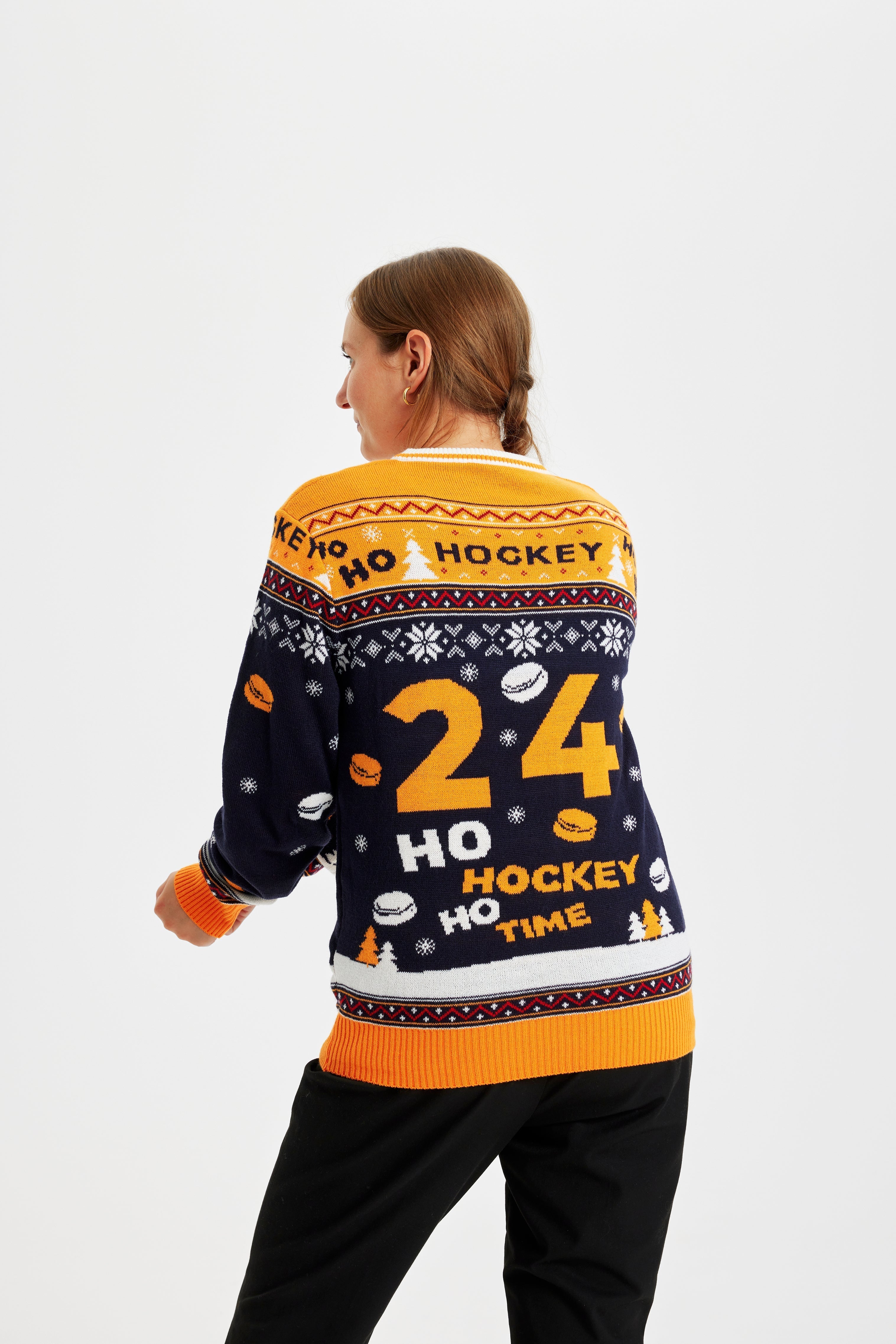 En kvinna med ryggen vänd bär en jultröja med en tomte som spelar hockey.