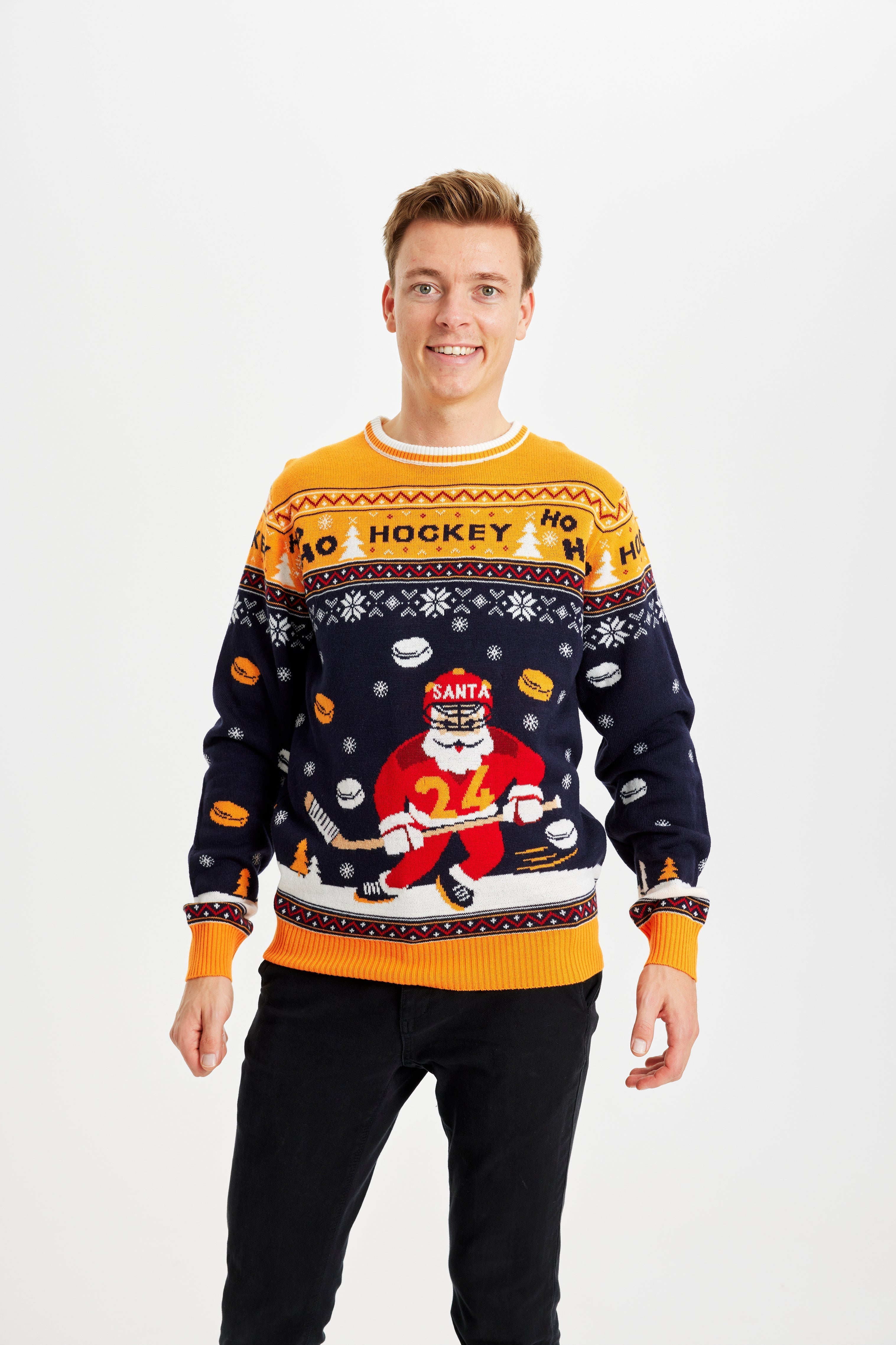 En leende man i jultröja med en jultomte som spelar hockey.