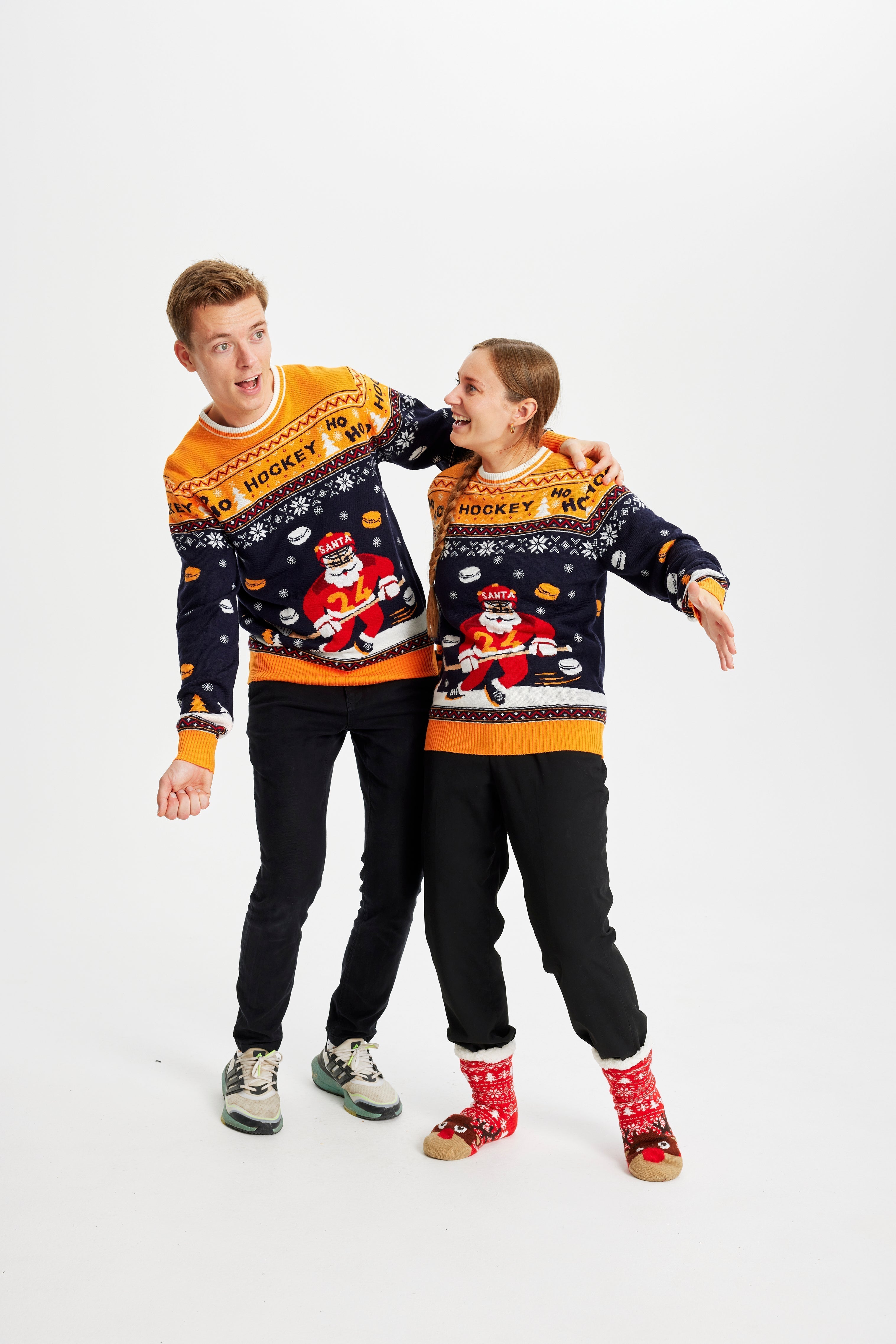 Ett par i jultröja med en jultomte som spelar hockey.