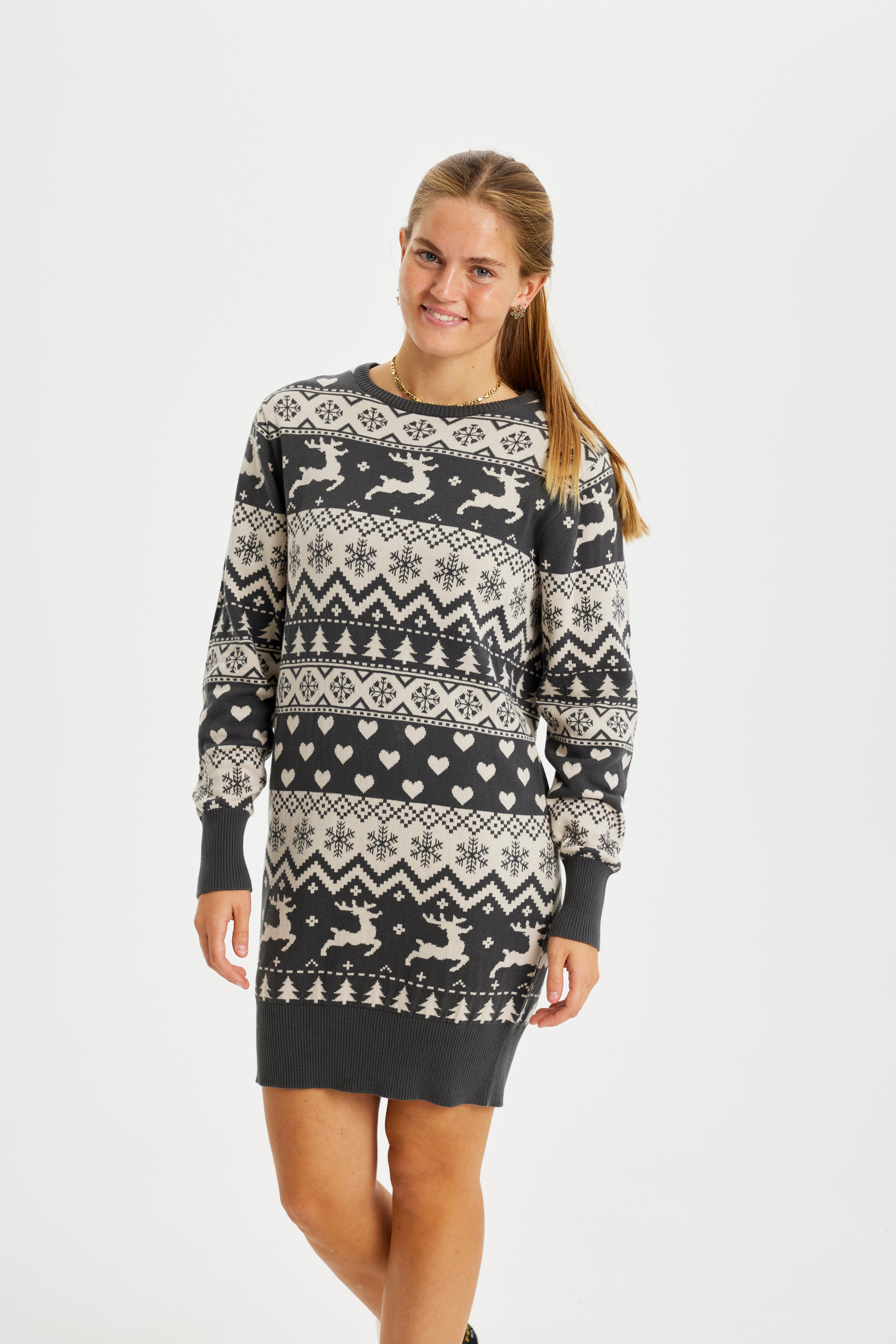 En poserande kvinna bär en gråmönstrad julklänning.