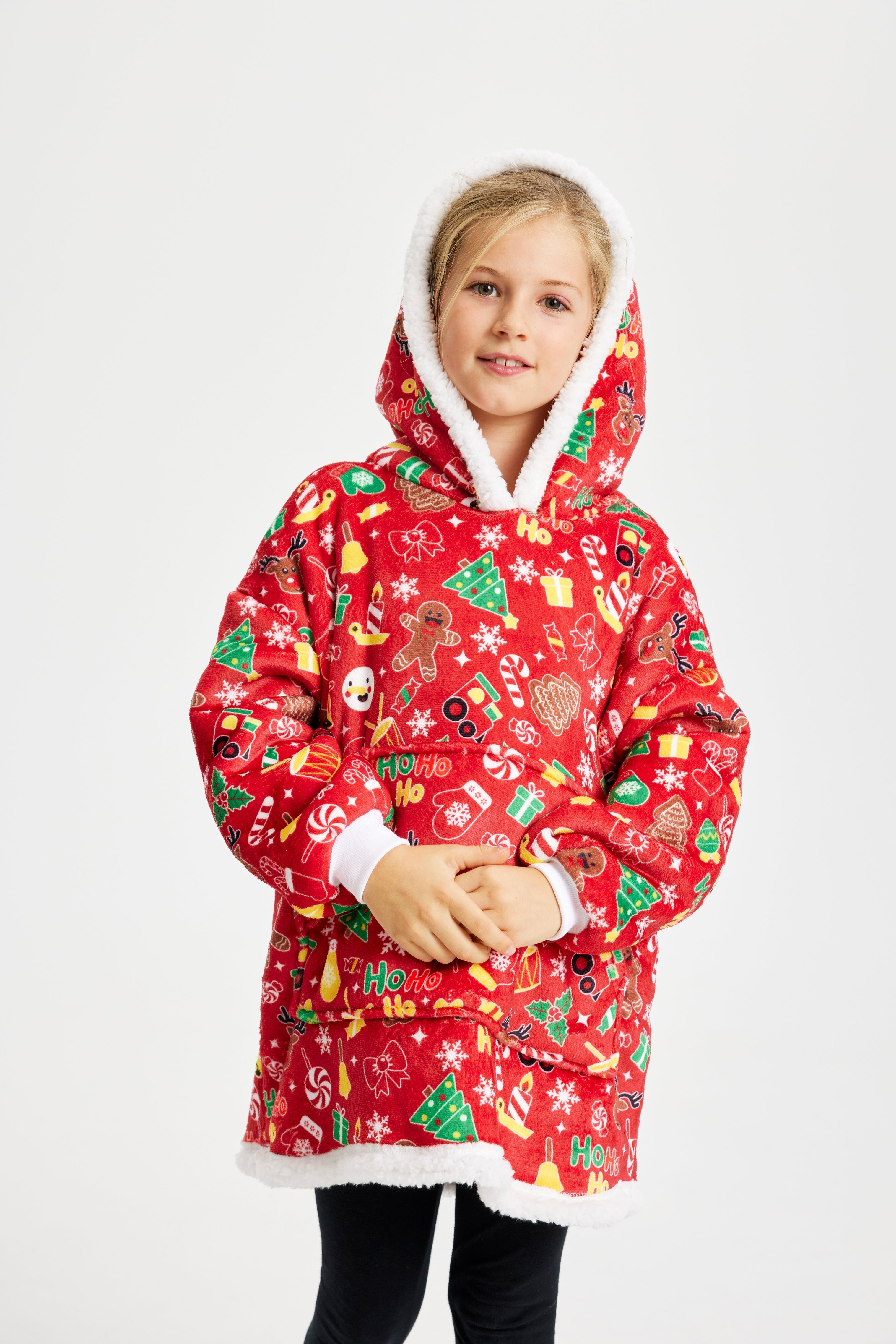 Ett sött barn i en röd julig huvtröja med julmönster på.