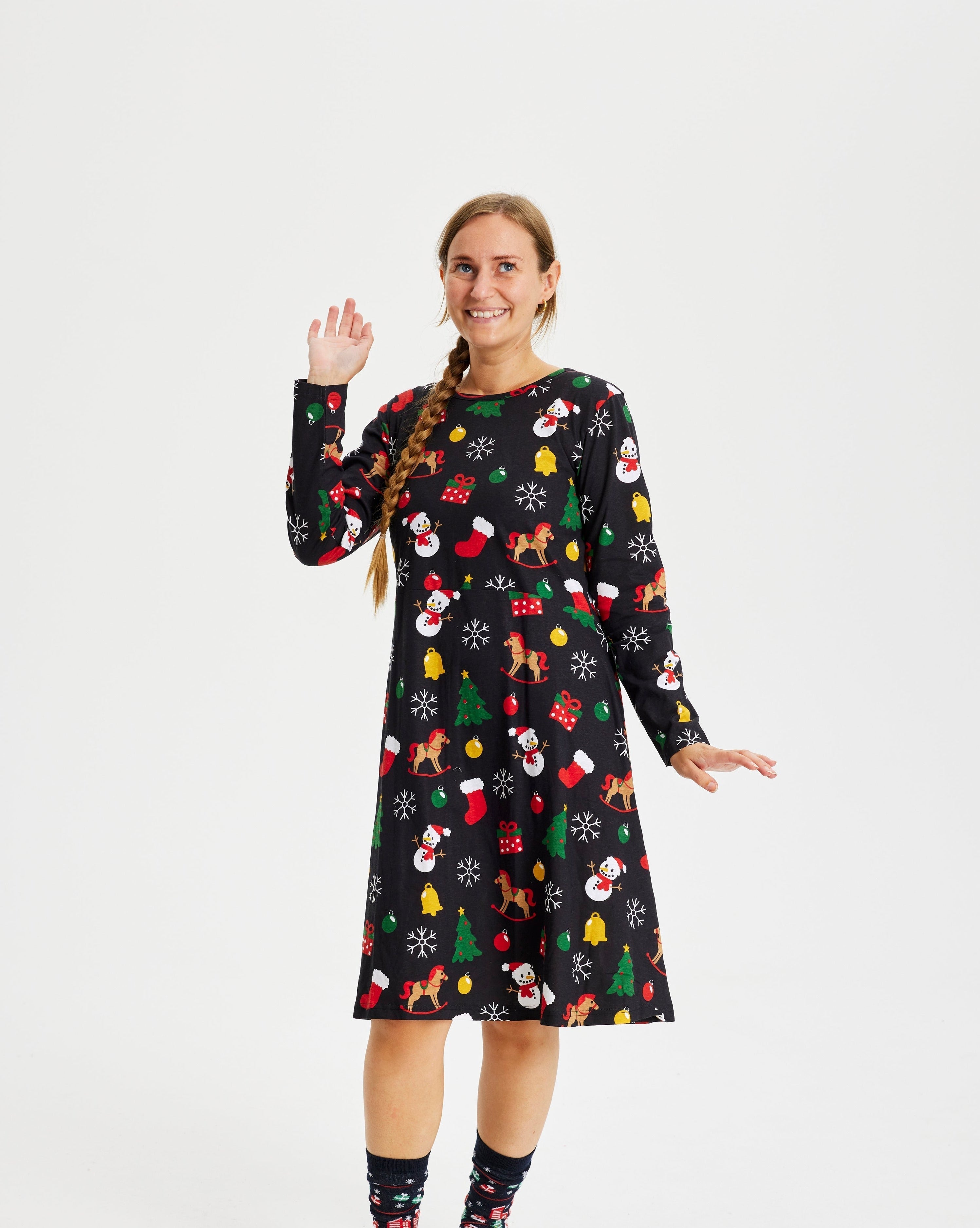 En kvinde i en sort julekjole med julemønster på.