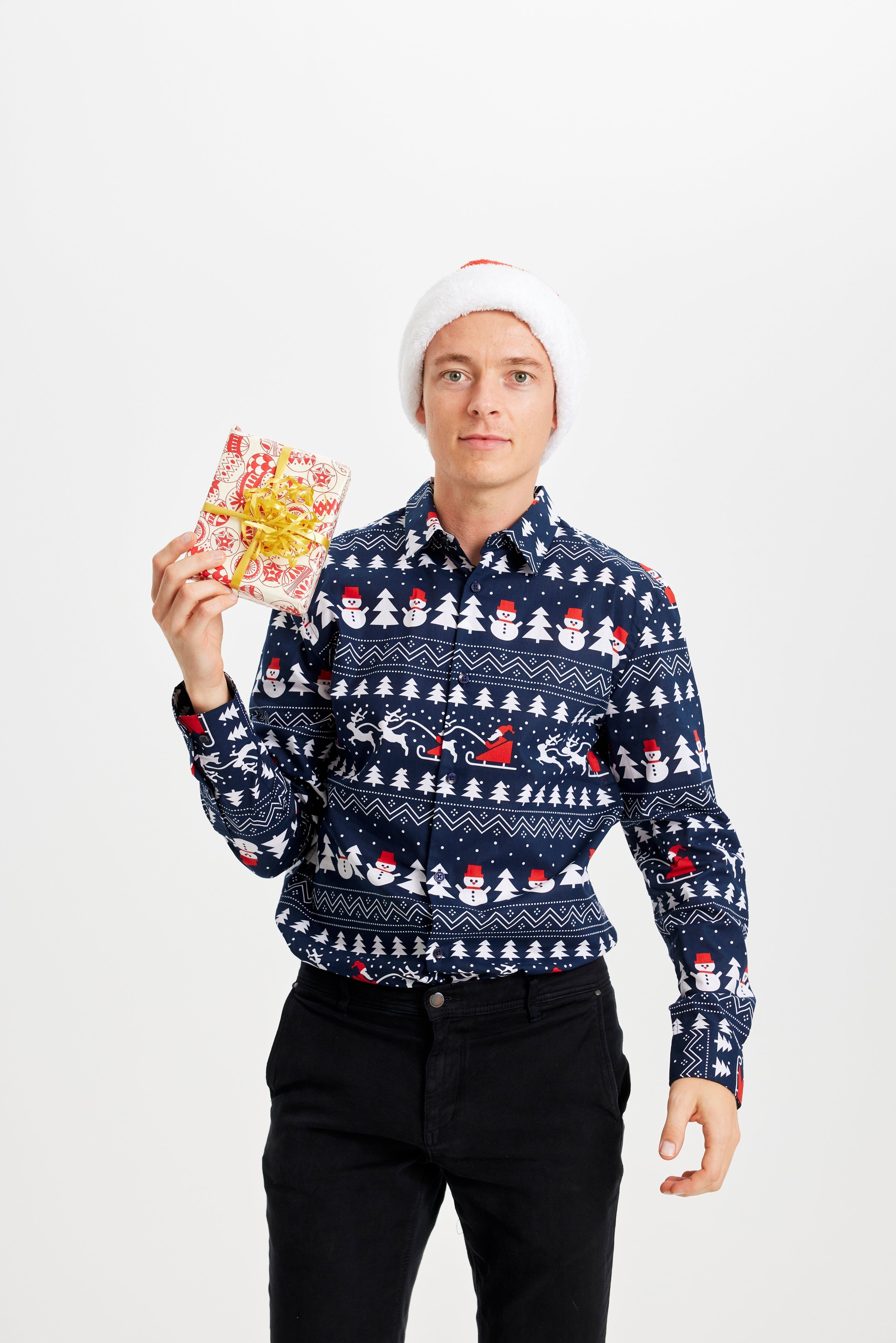 En man i en blå jultröja med julgranar och snögubbar på.