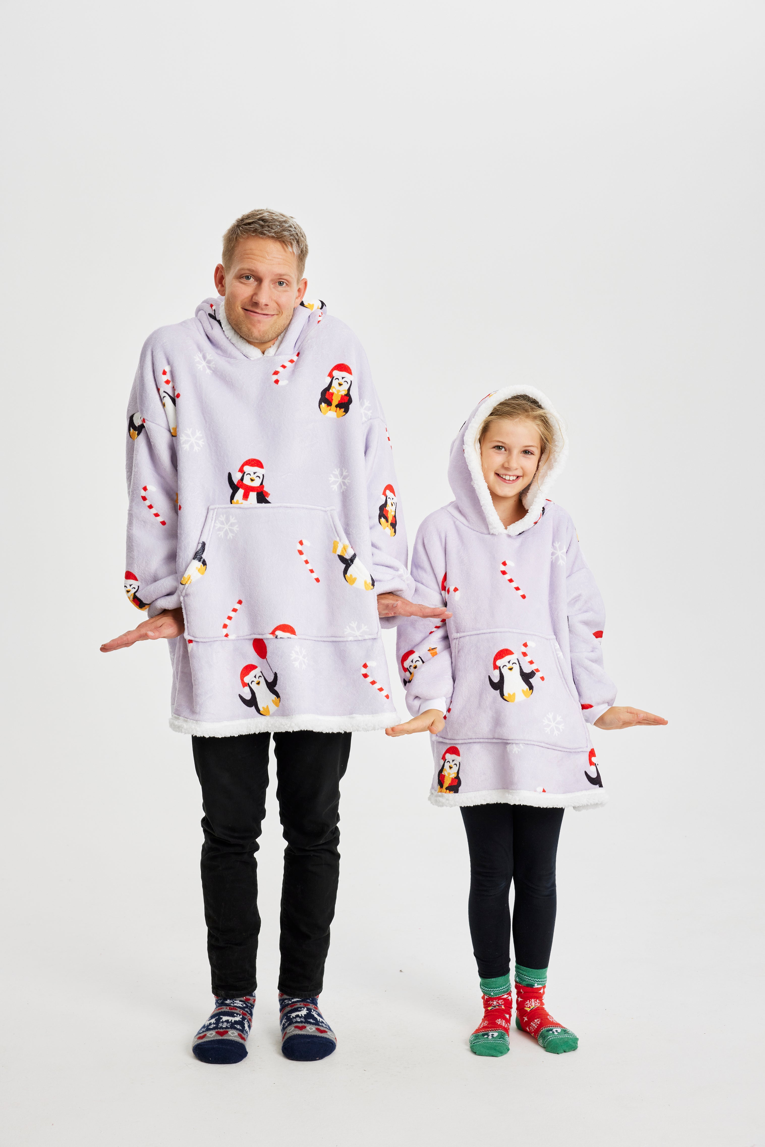 Ett barn och en man som bär en ljuslila huvtröja med pingviner på.