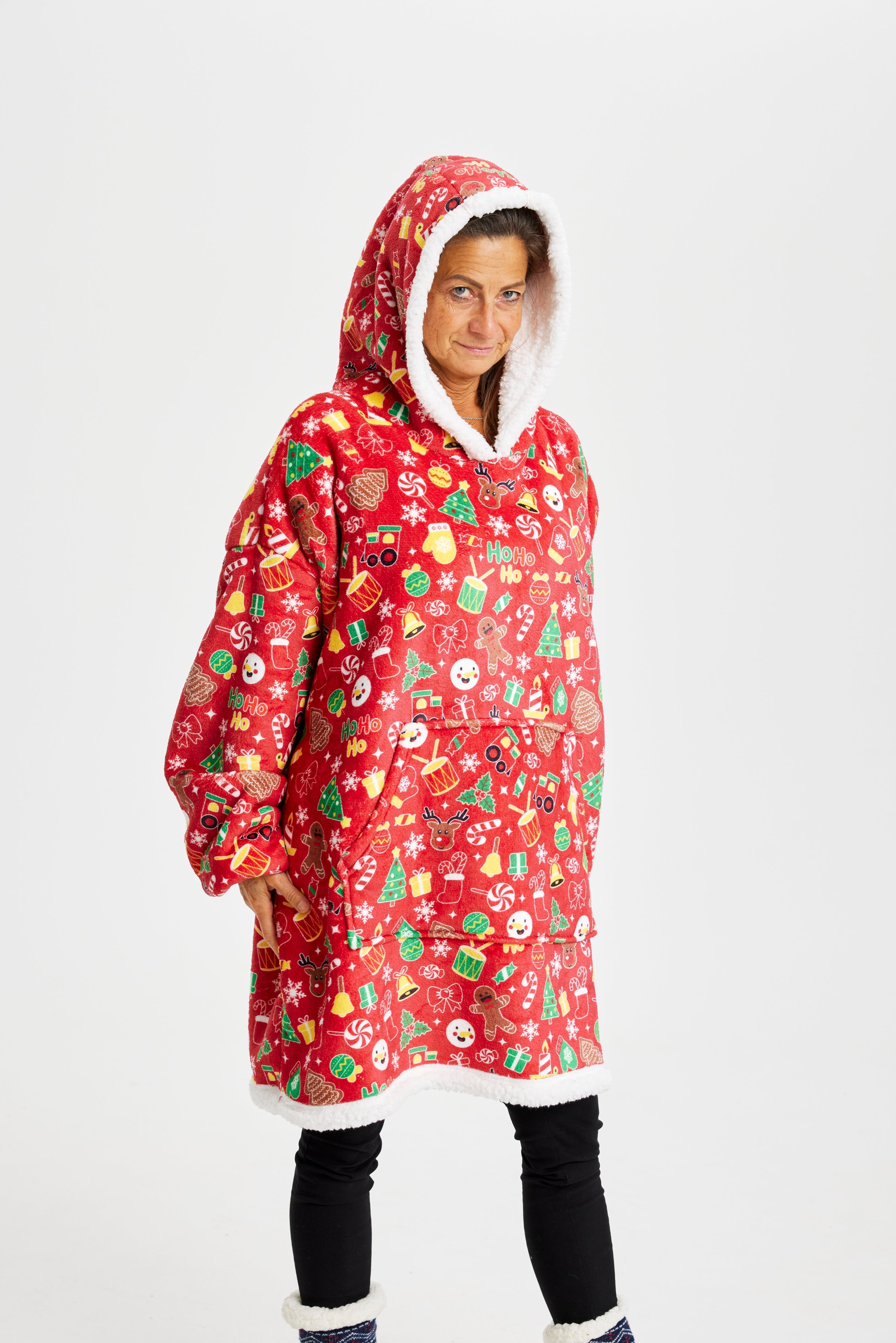 En kvinna med huva som bär en röd huvtröja med julmönster.
