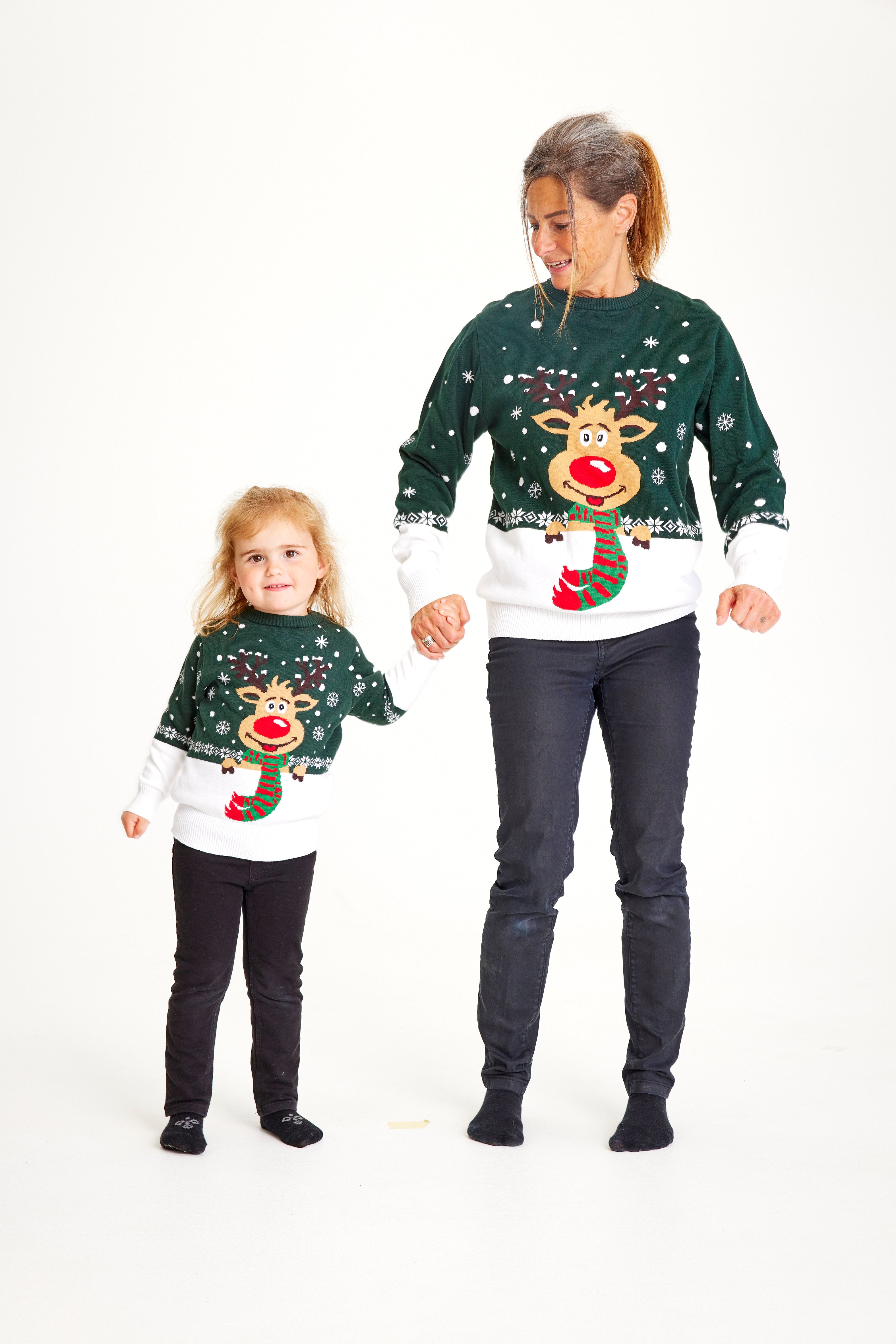 Ett barn och en kvinna i en grön och vit jultröja med Rudolf på.