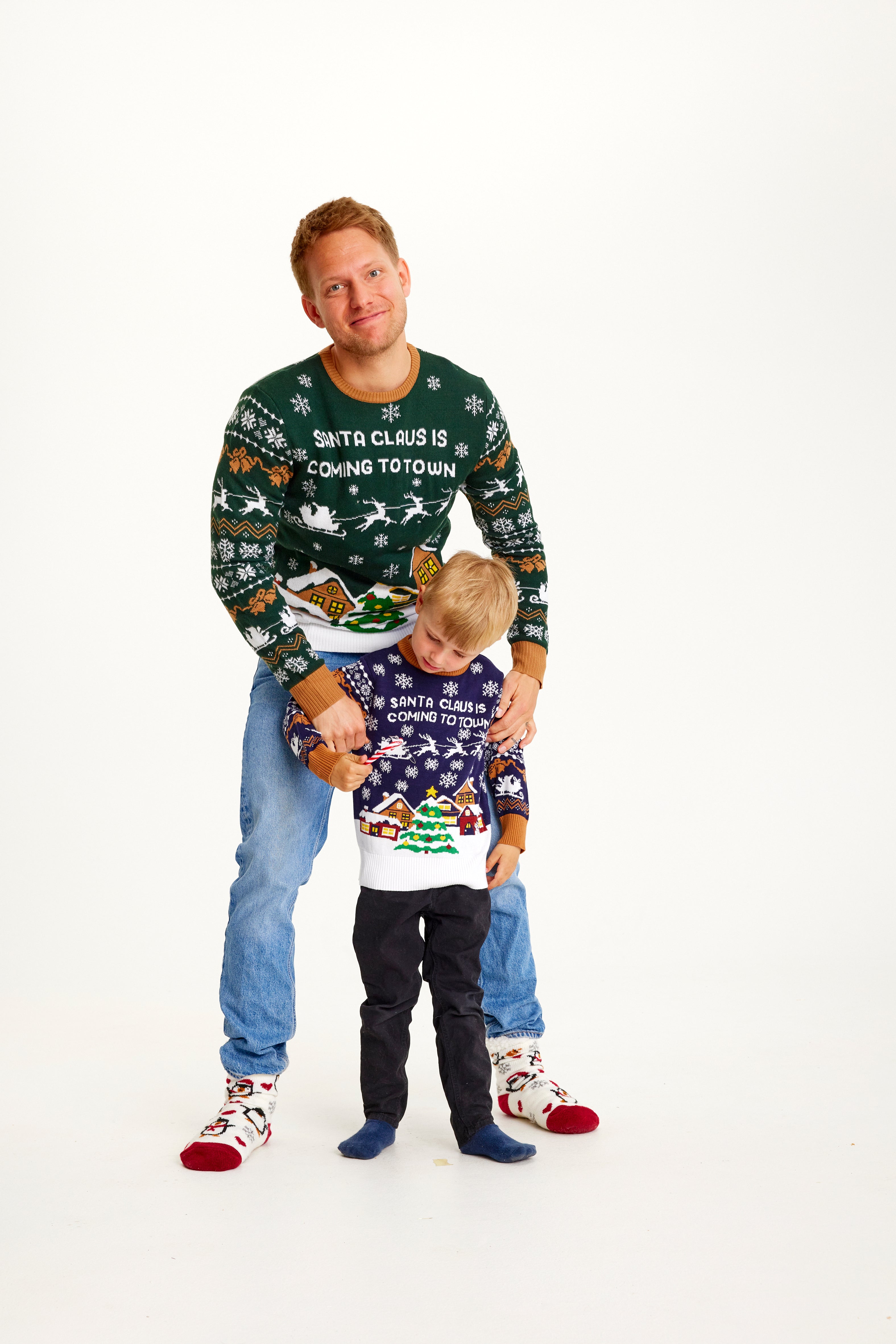 En man och ett barn i en jultröja med texten 