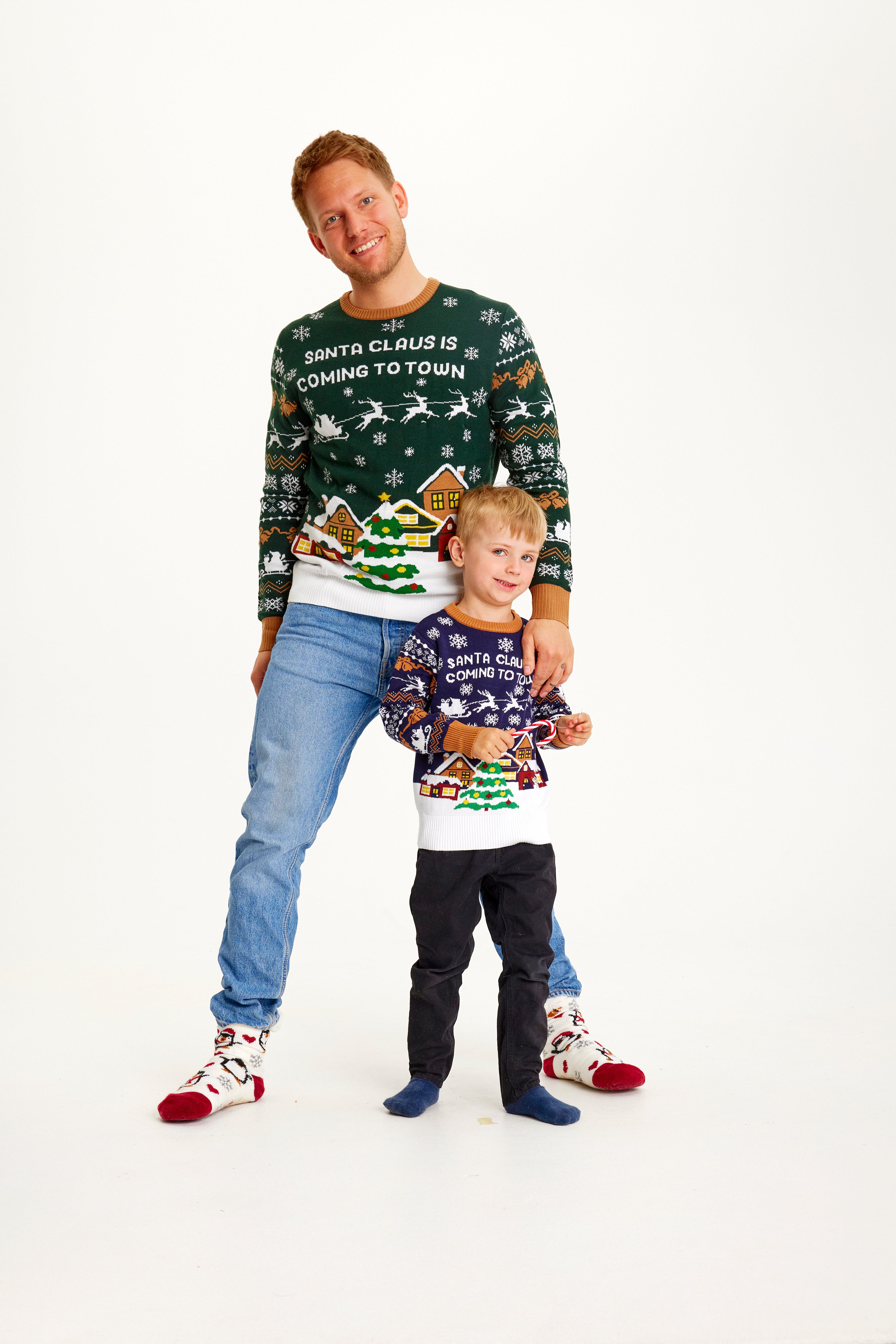En man och ett barn i en jultröja med texten 
