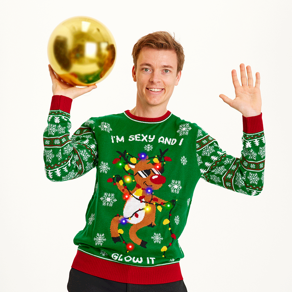Man i grön jultröja med dansande renar och ljus.