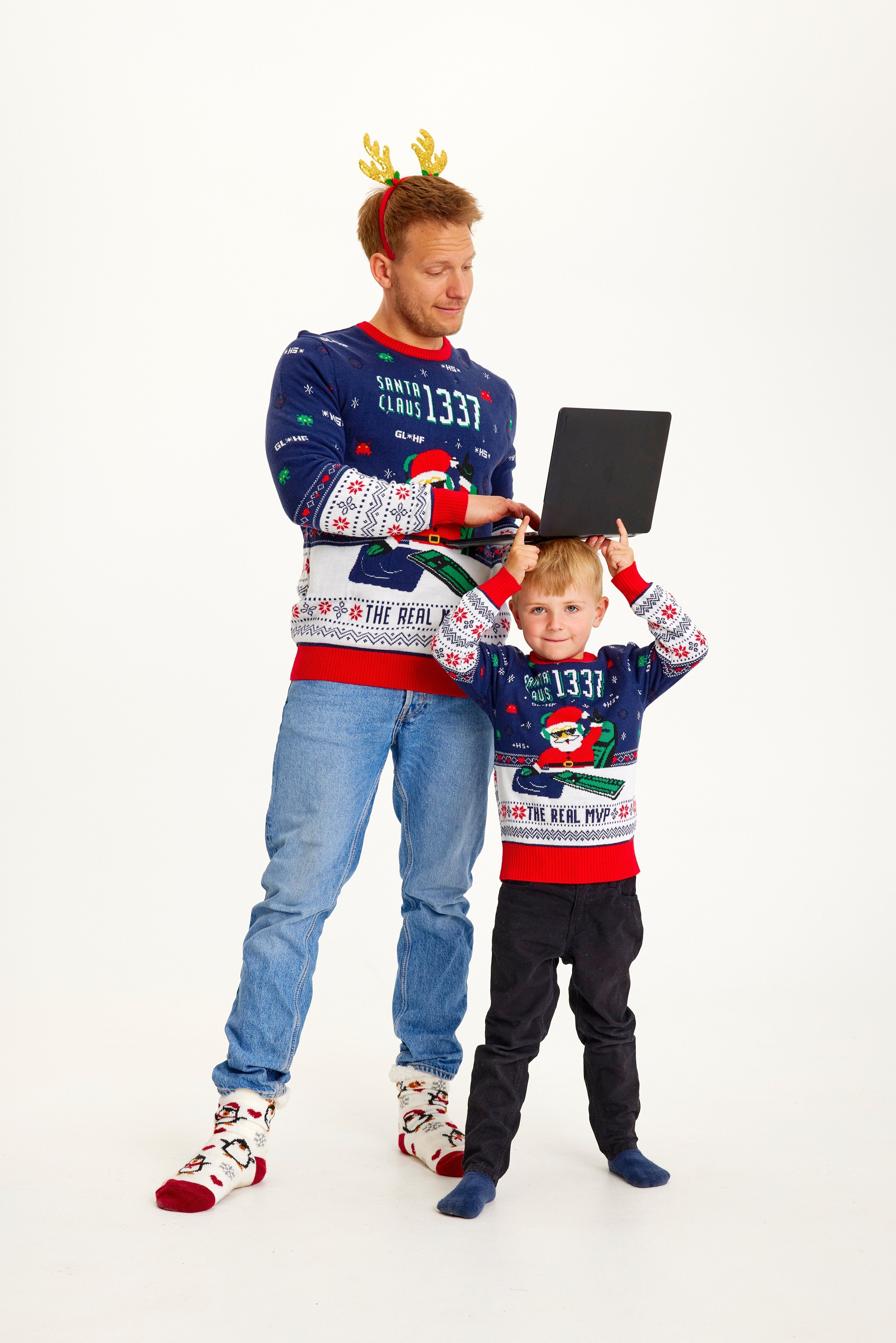 En man och ett barn bär en jultröja med en jultomte och citatet 