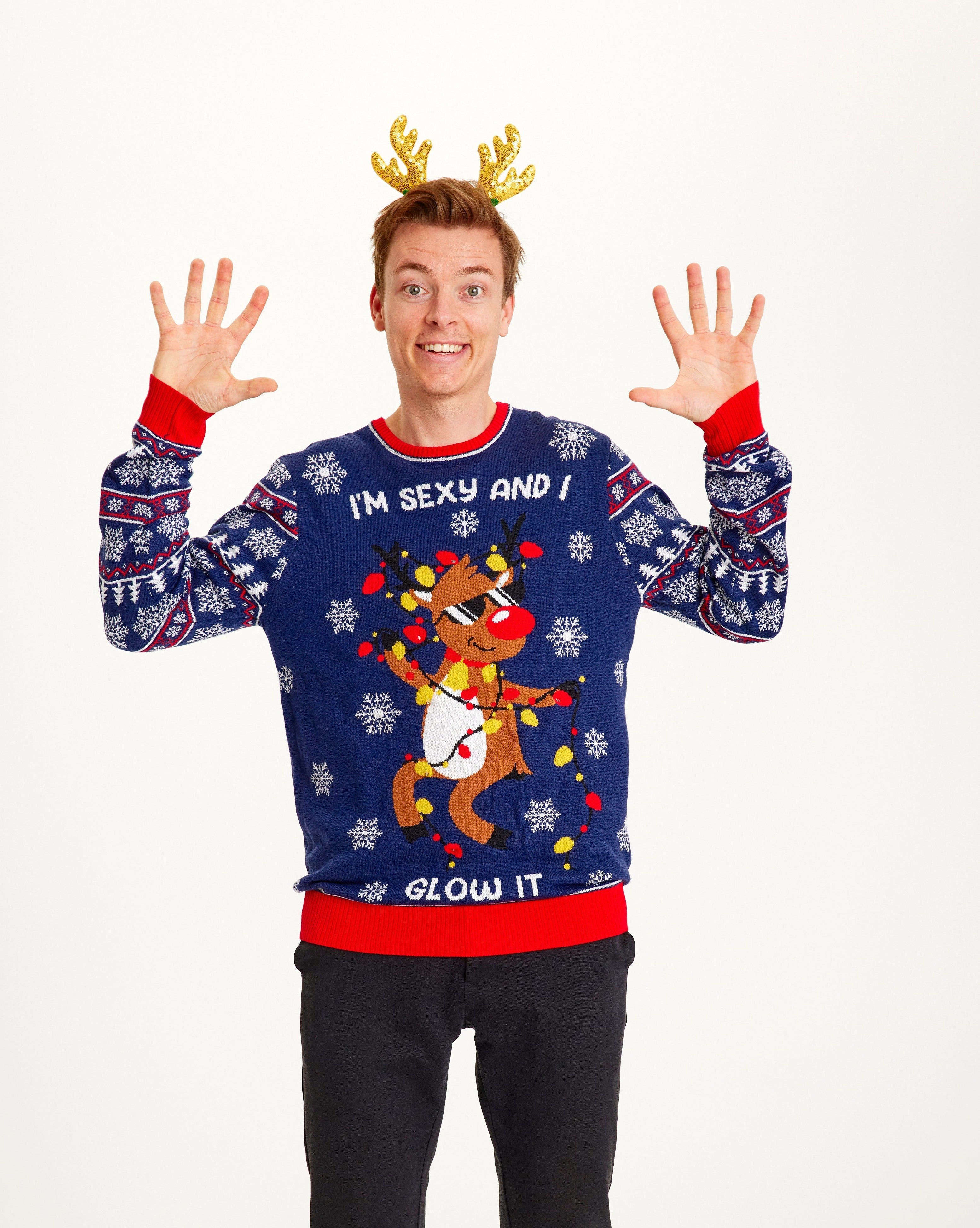 En man i blå jultröja med en dansande ren och ljus.