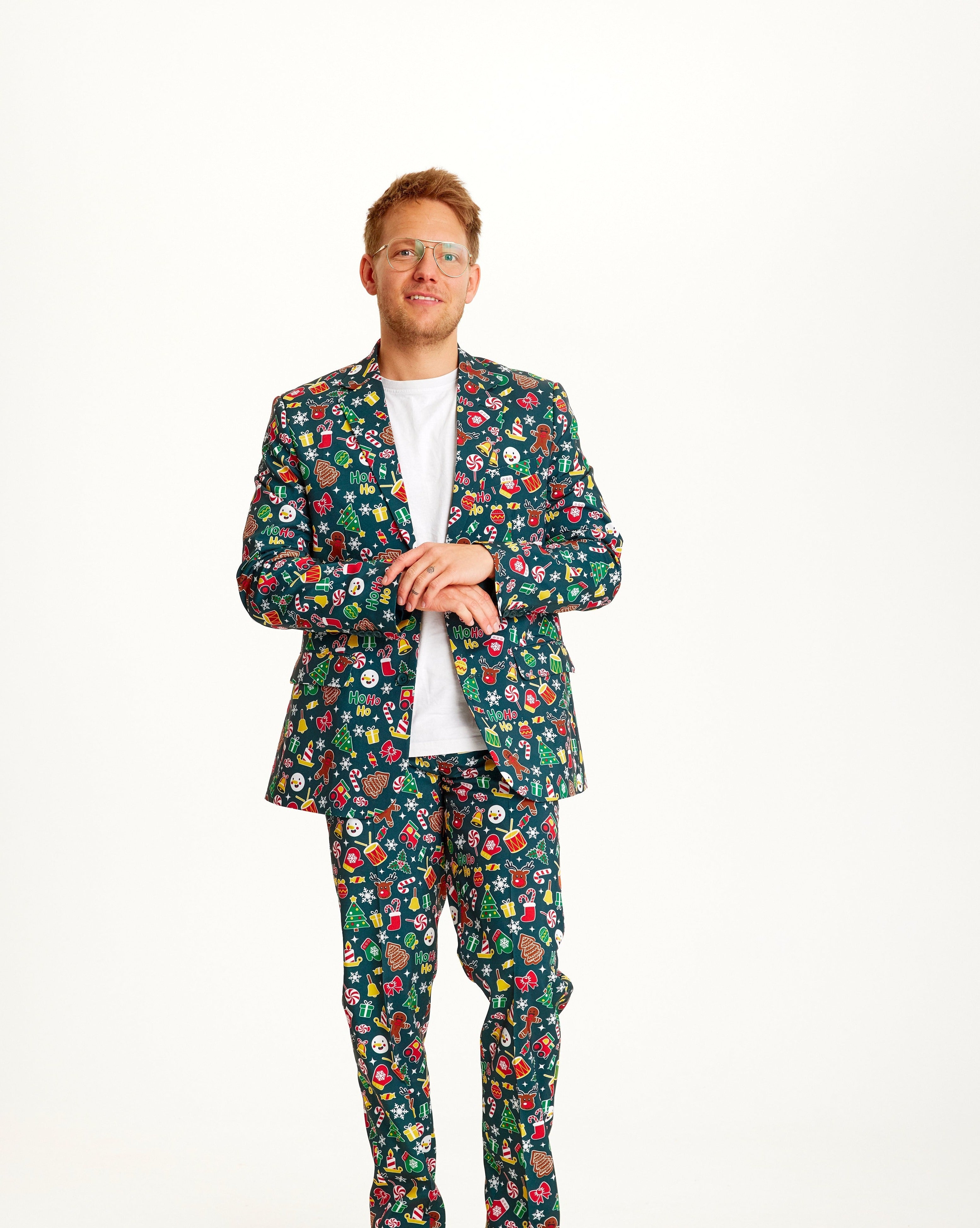 En man klädd i en grön kostym med ett julmönster på.
