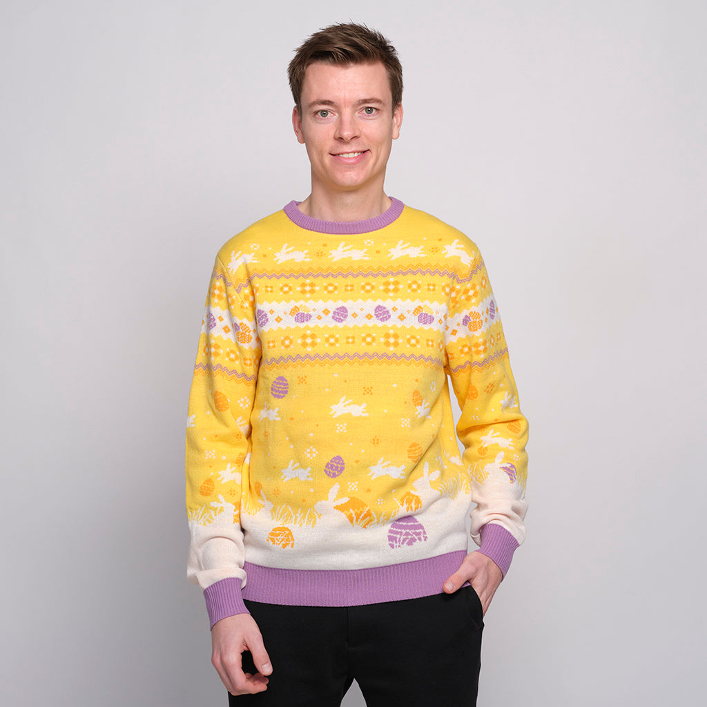 En leende man som bär en gul påsktröja med påskägg på.