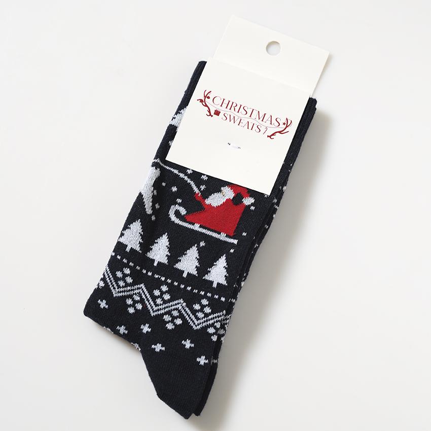 Ett par svarta julstrumpor med julgranar och julmönster.